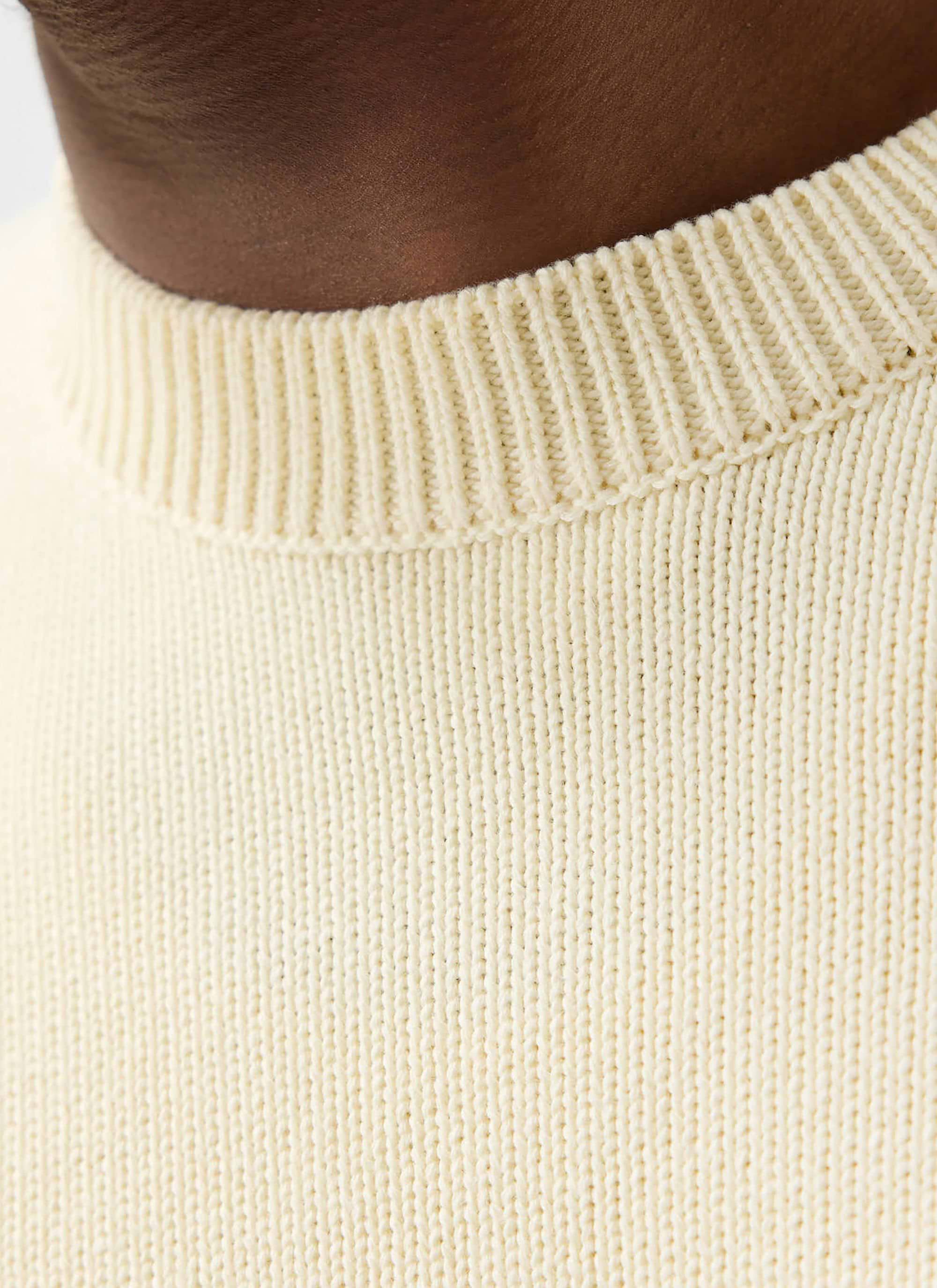 A detailed close-up of the ribbed crew neck on the Percival Public Library Knitted Jumper in ecru cream.