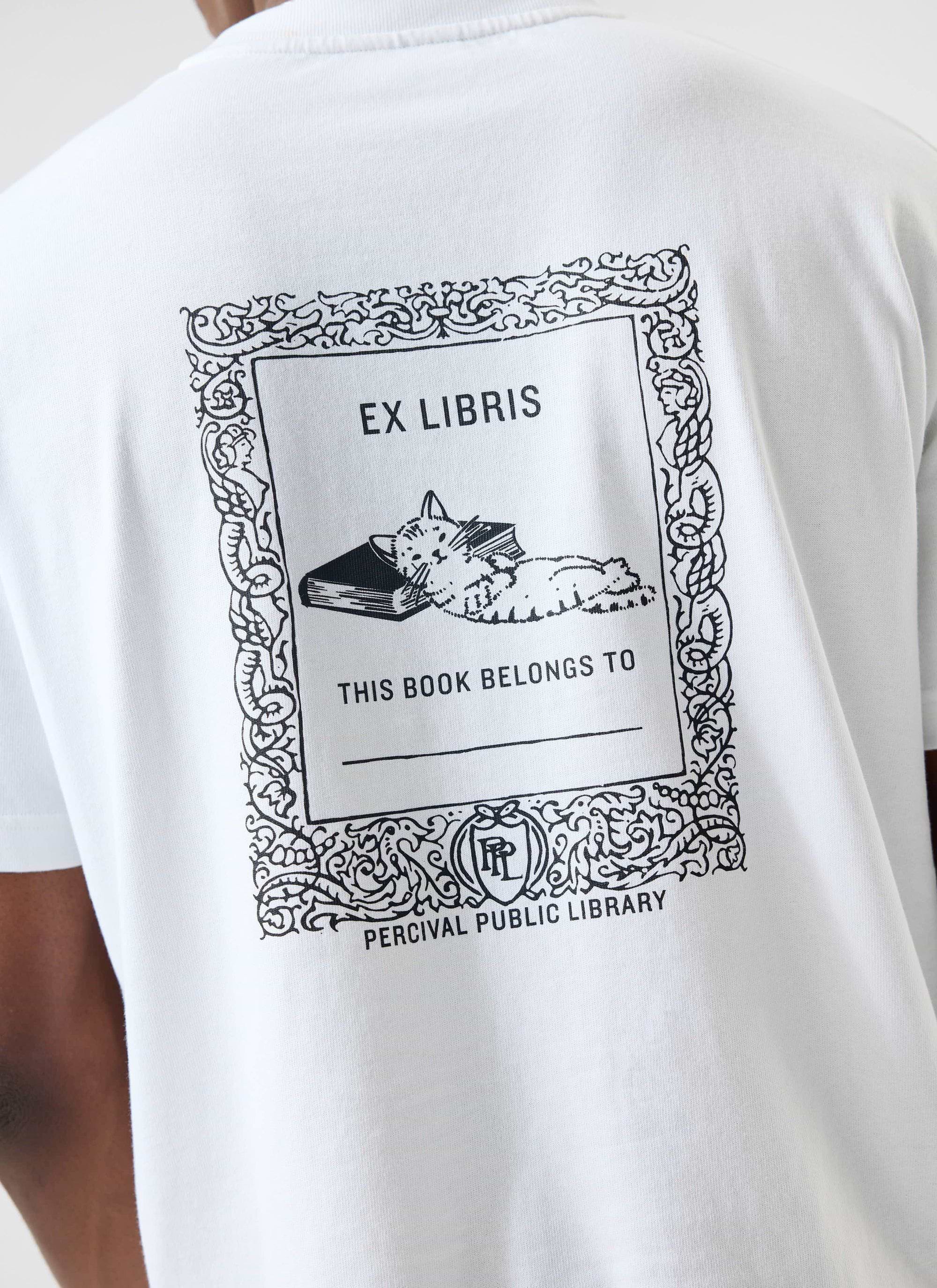 A close-up of the back of the white Percival Ex Libris T-shirt, showing the 'Public Library' graphic with a sleeping cat.