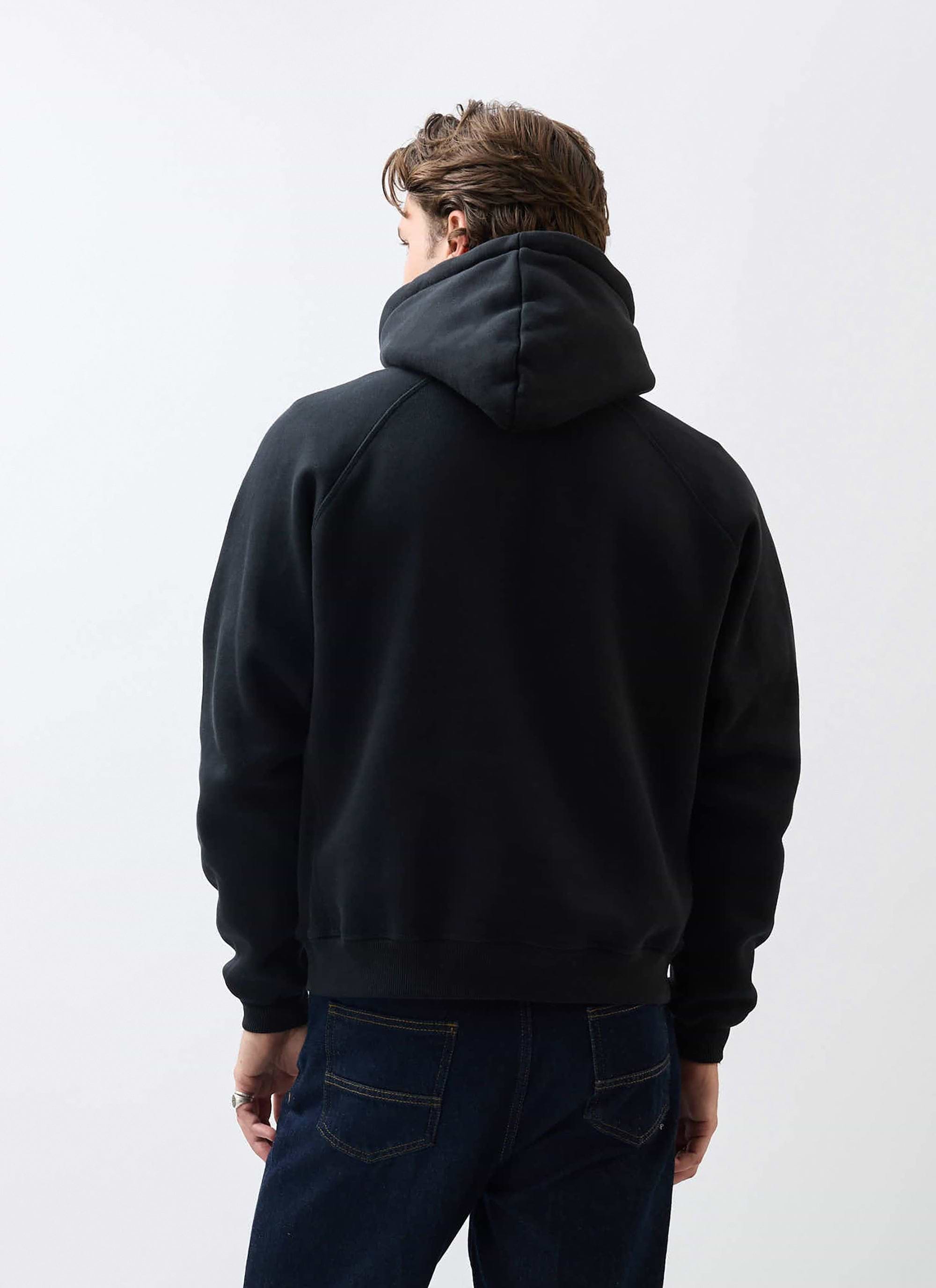 The back of a model wearing the black Percival Heritage 90's Hoodie, showing the classic raglan sleeve design.