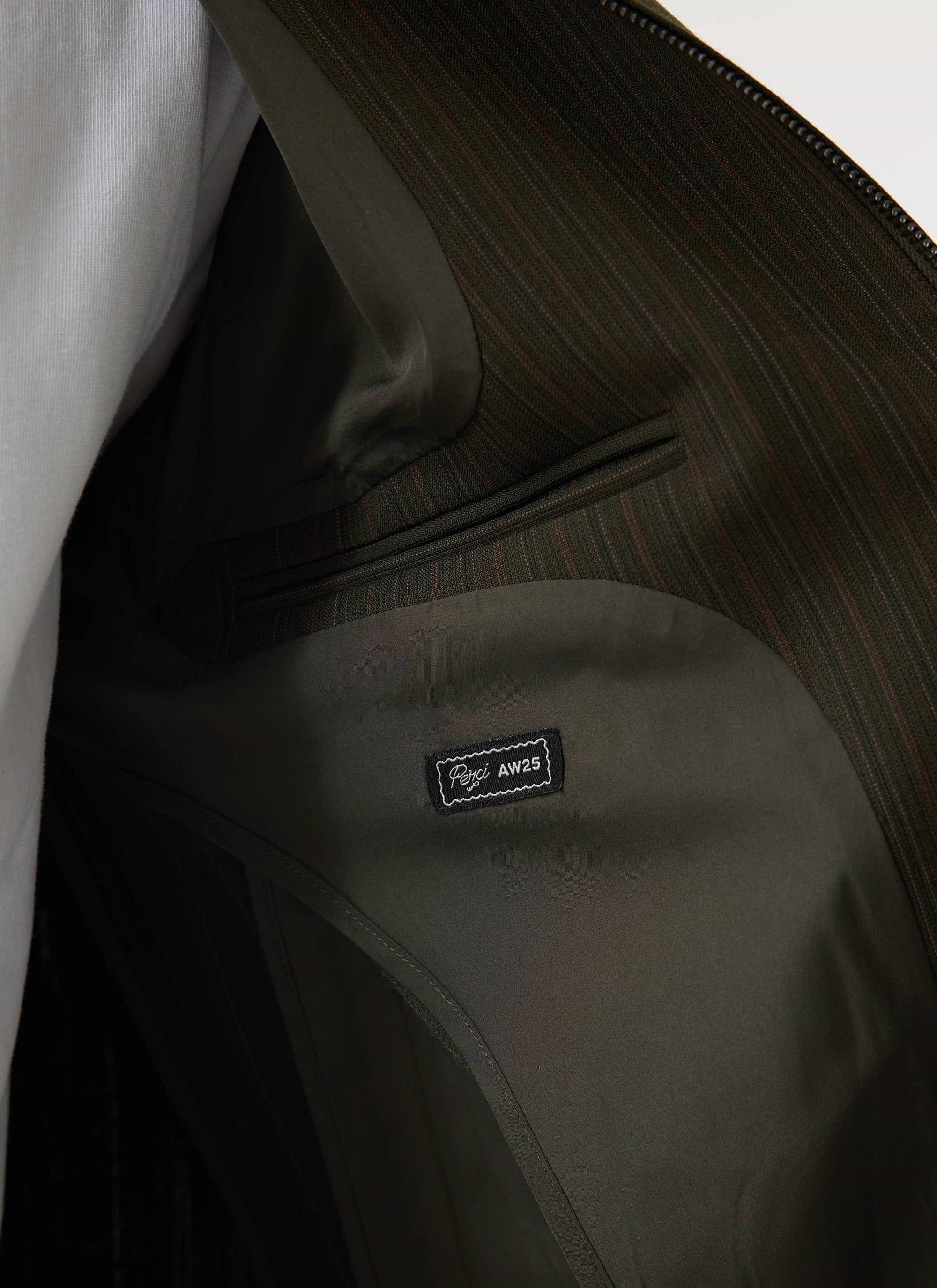 Close-up of the internal welt pocket and forest green lining of the Percival Chapter Zip Up Jacket.