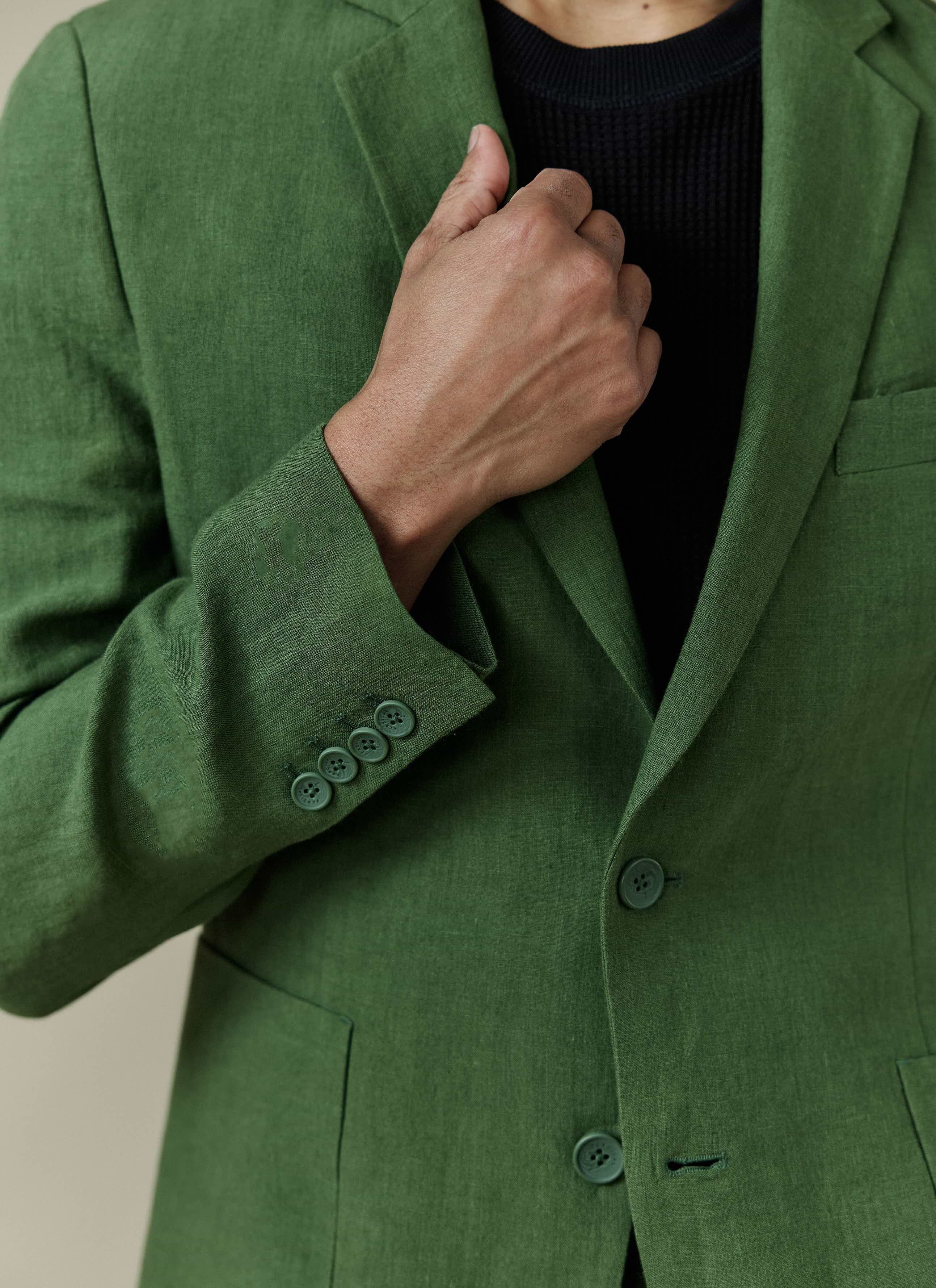 Forest green Percival Tailored Linen Blazer, shown in a close-up highlighting the textured fabric and buttoned cuffs.