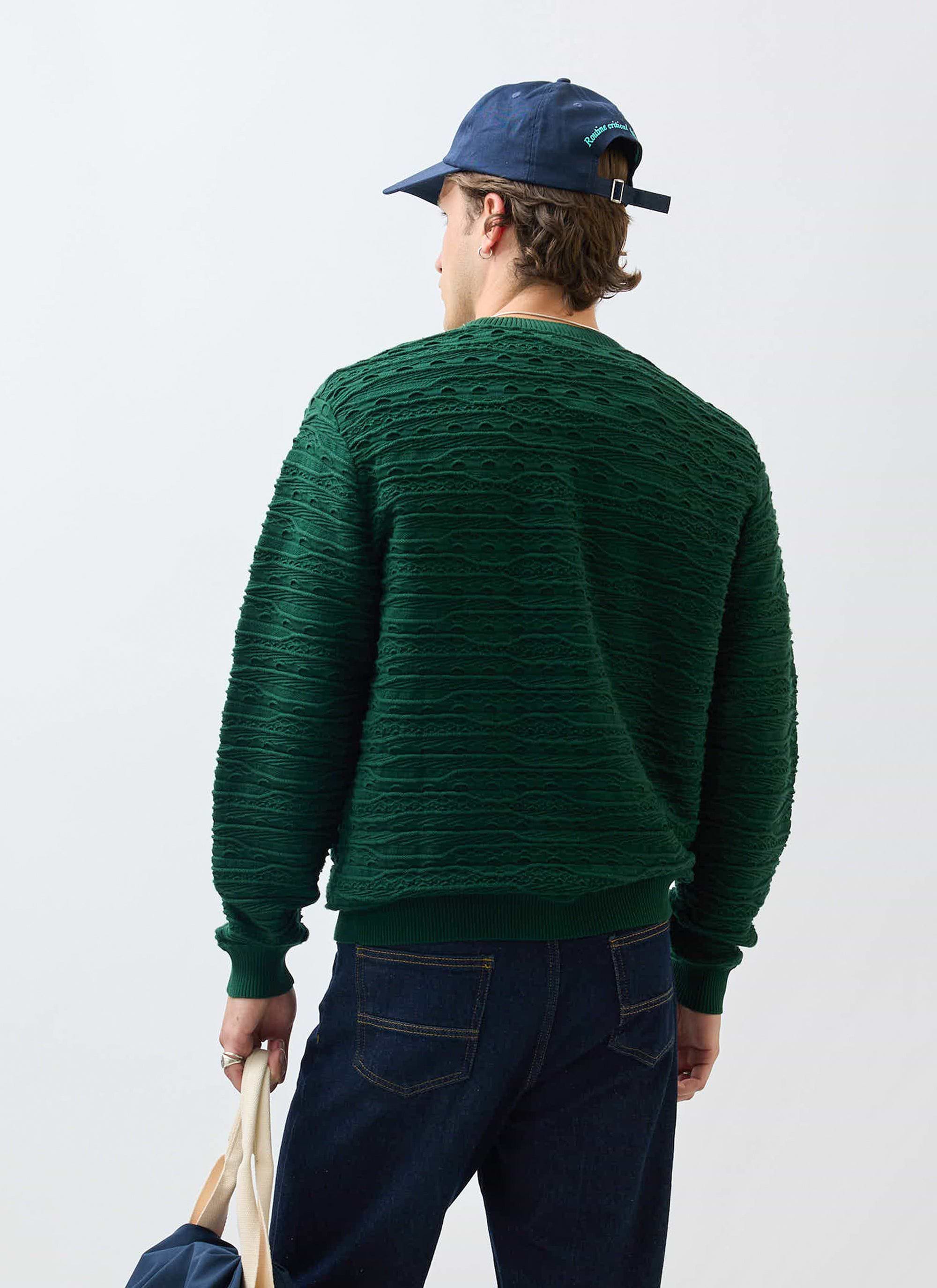 A model seen from behind wearing the Percival Tales Knitted Jumper in forest green, highlighting the unique textural knit.