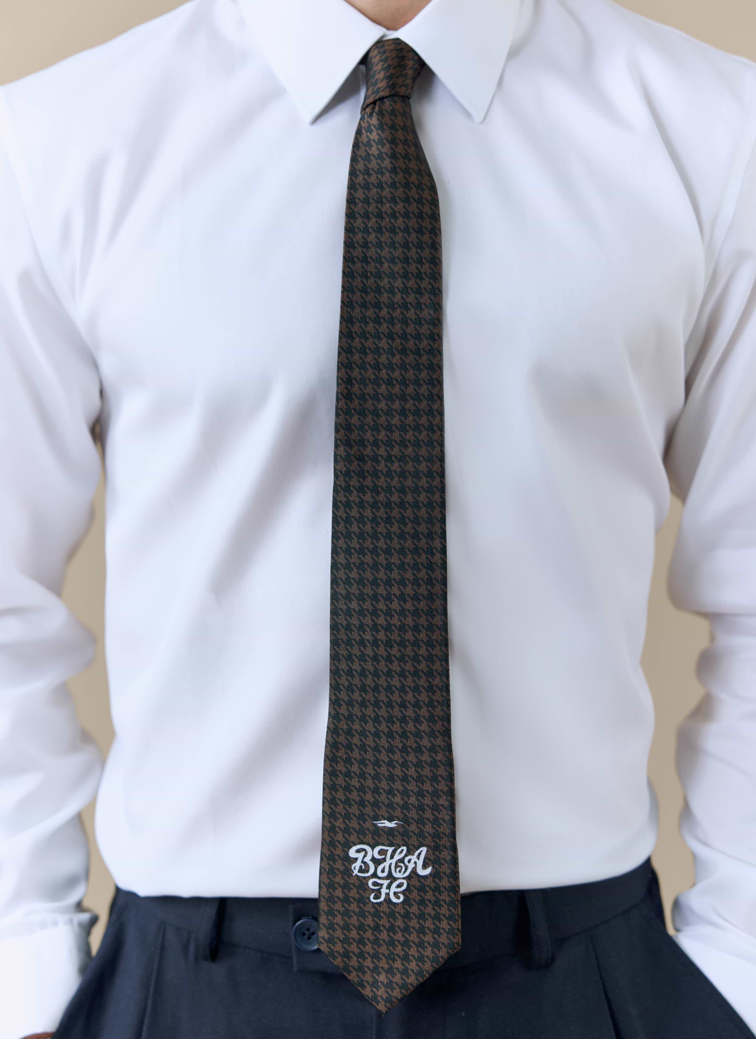 A model wearing the Percival x Brighton & Hove Albion F.C. brown houndstooth silk tie with a crisp white shirt.