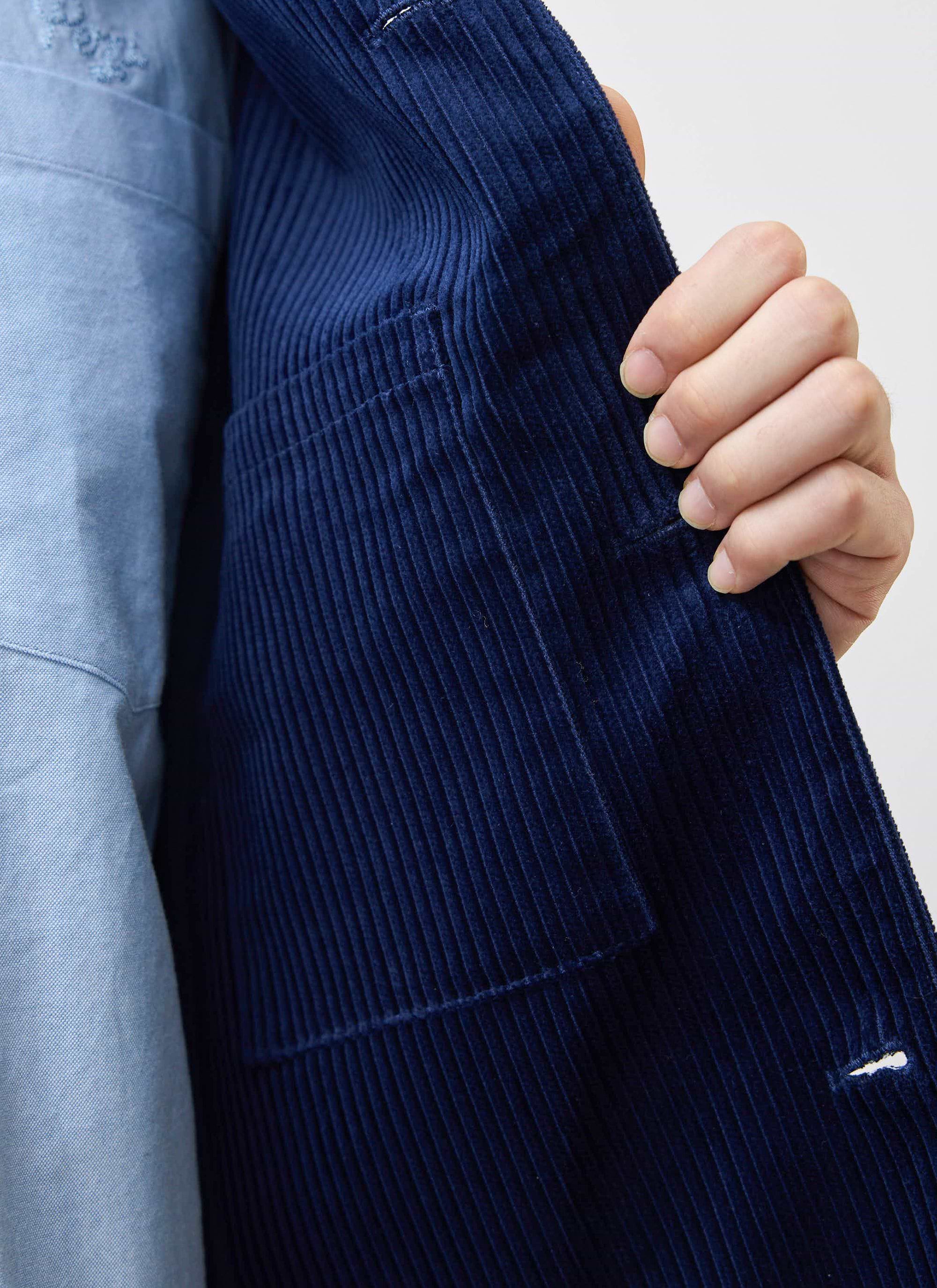 A close-up of the Percival navy cord overshirt, showing the internal pocket detail and heavyweight corduroy fabric.