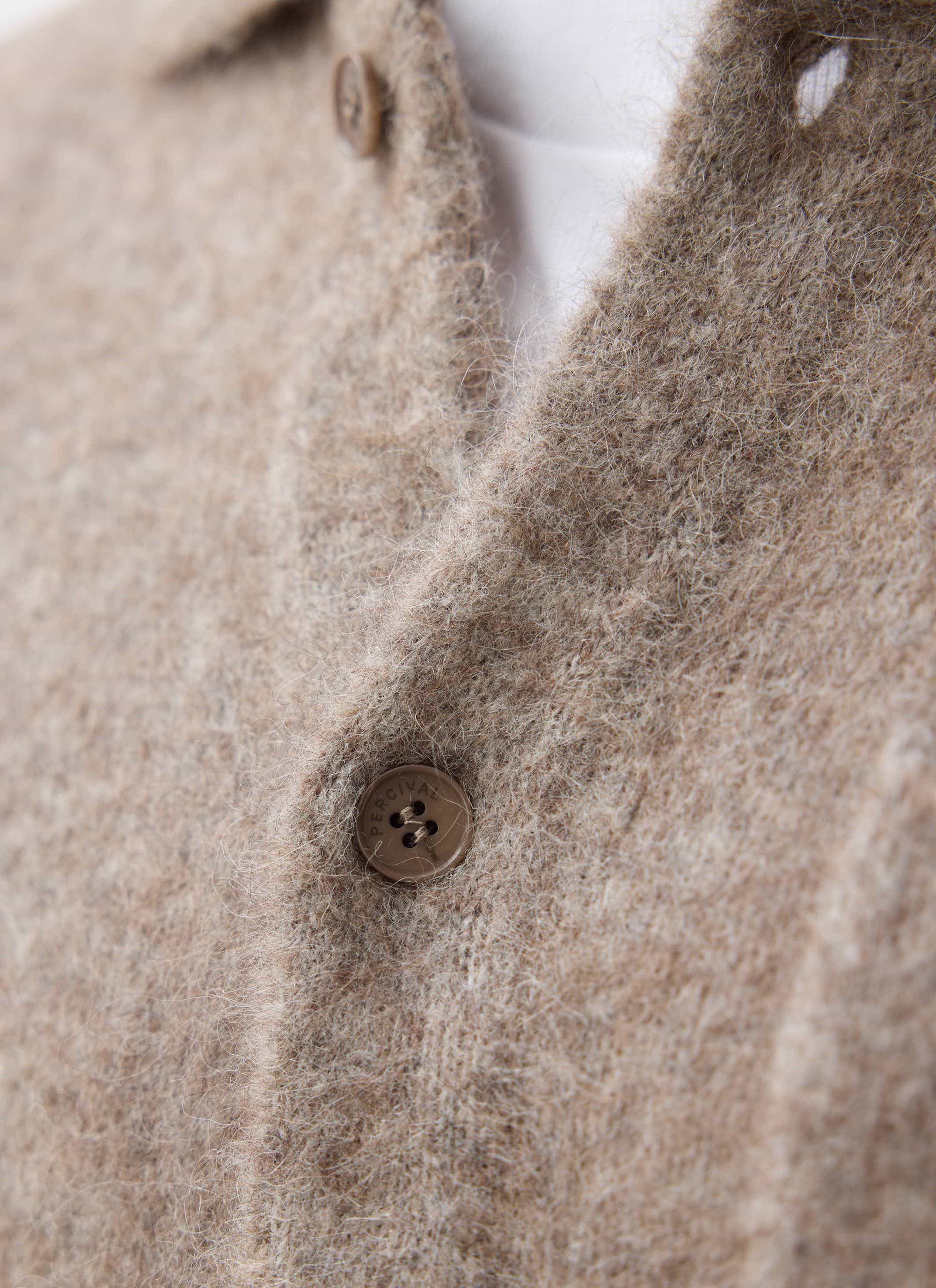 A close-up showing the soft wool-blend texture and custom branded button of the Novel Collared Cardigan in Oak from Percival.