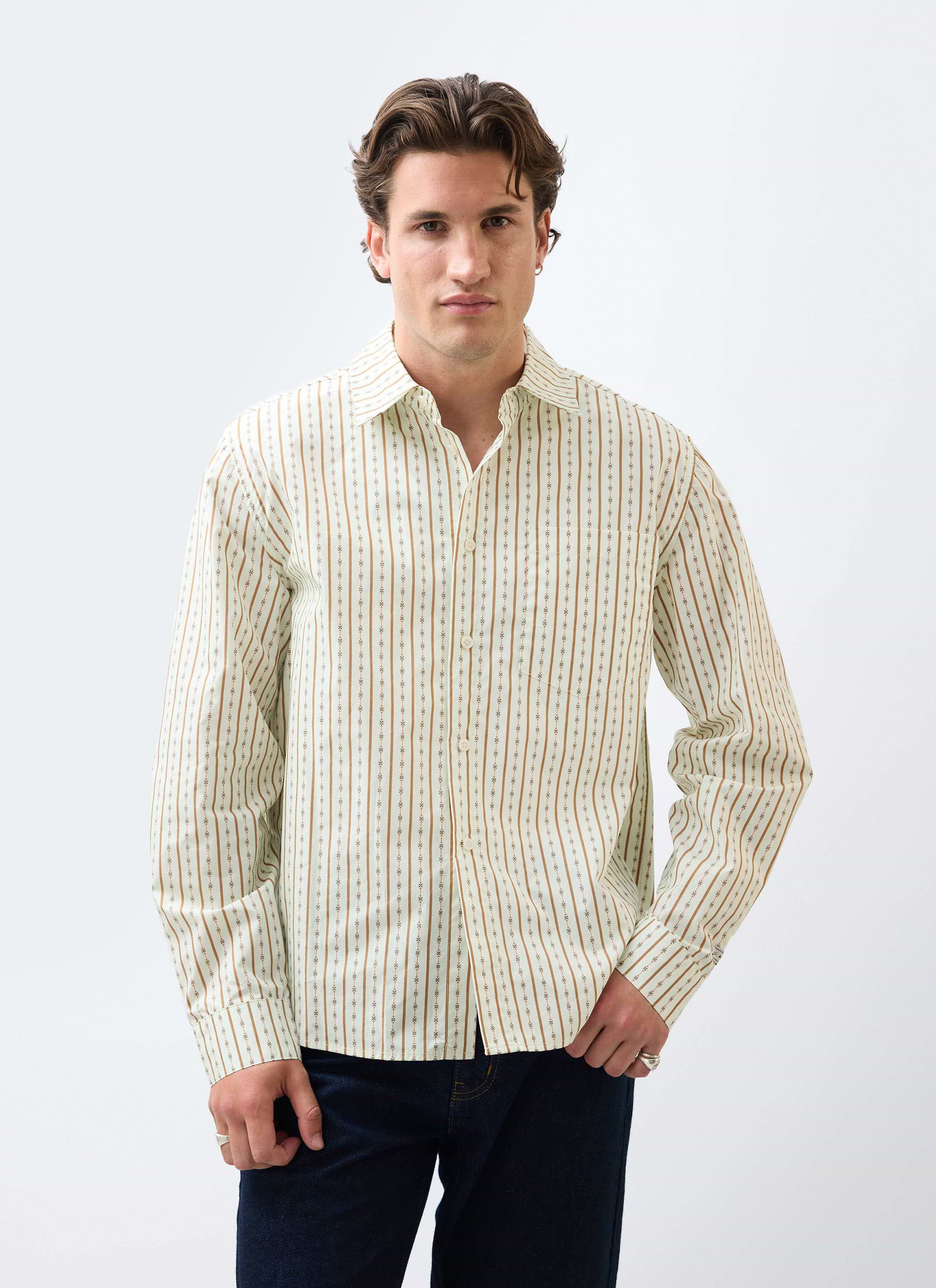 The Percival Binding Oversized Pearce Shirt in ecru cotton, worn by a model with dark denim against a white background.