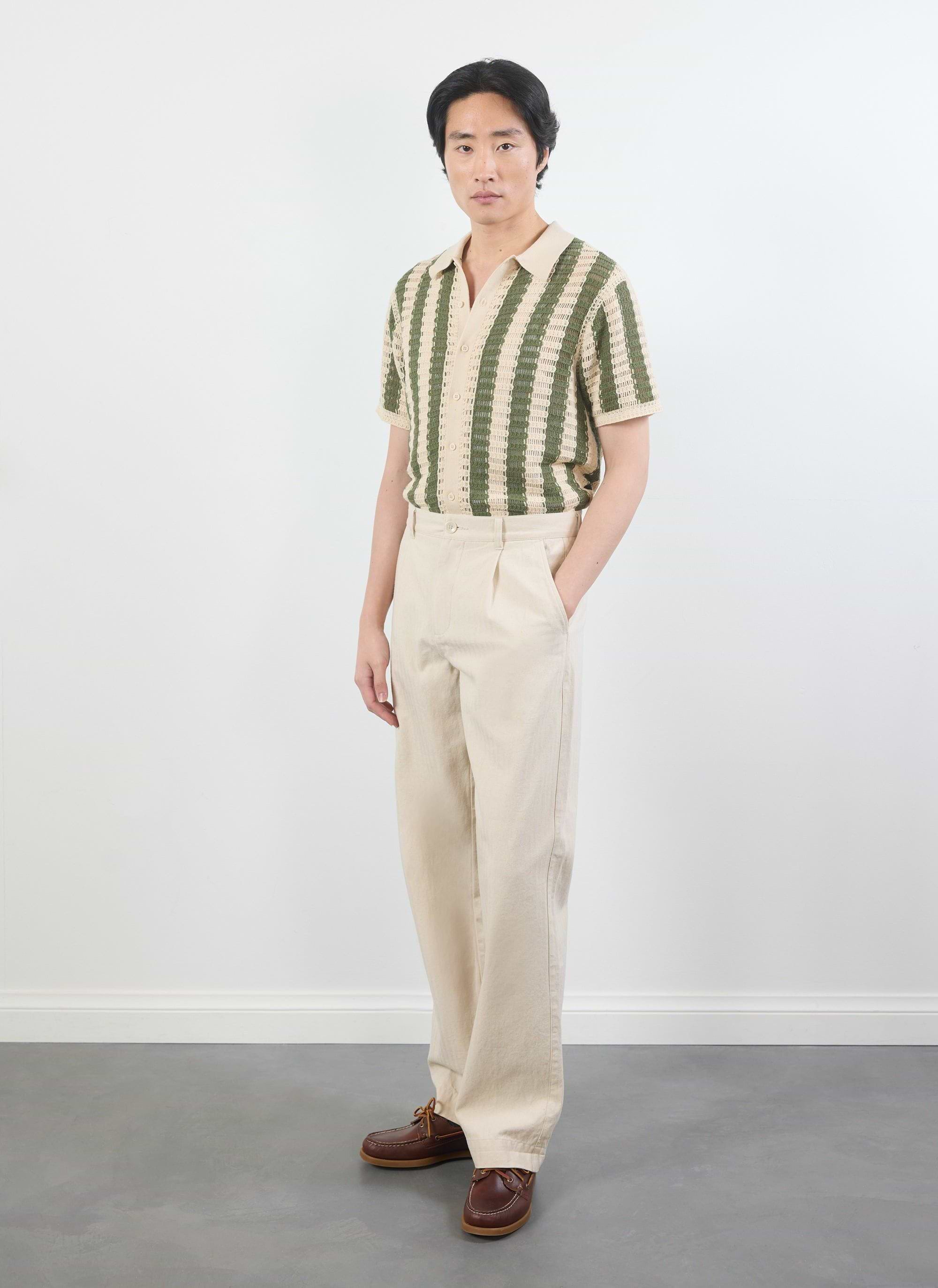 A model wears the Percival Barletta Knitted Shirt in olive green and cream, paired with light-coloured trousers.