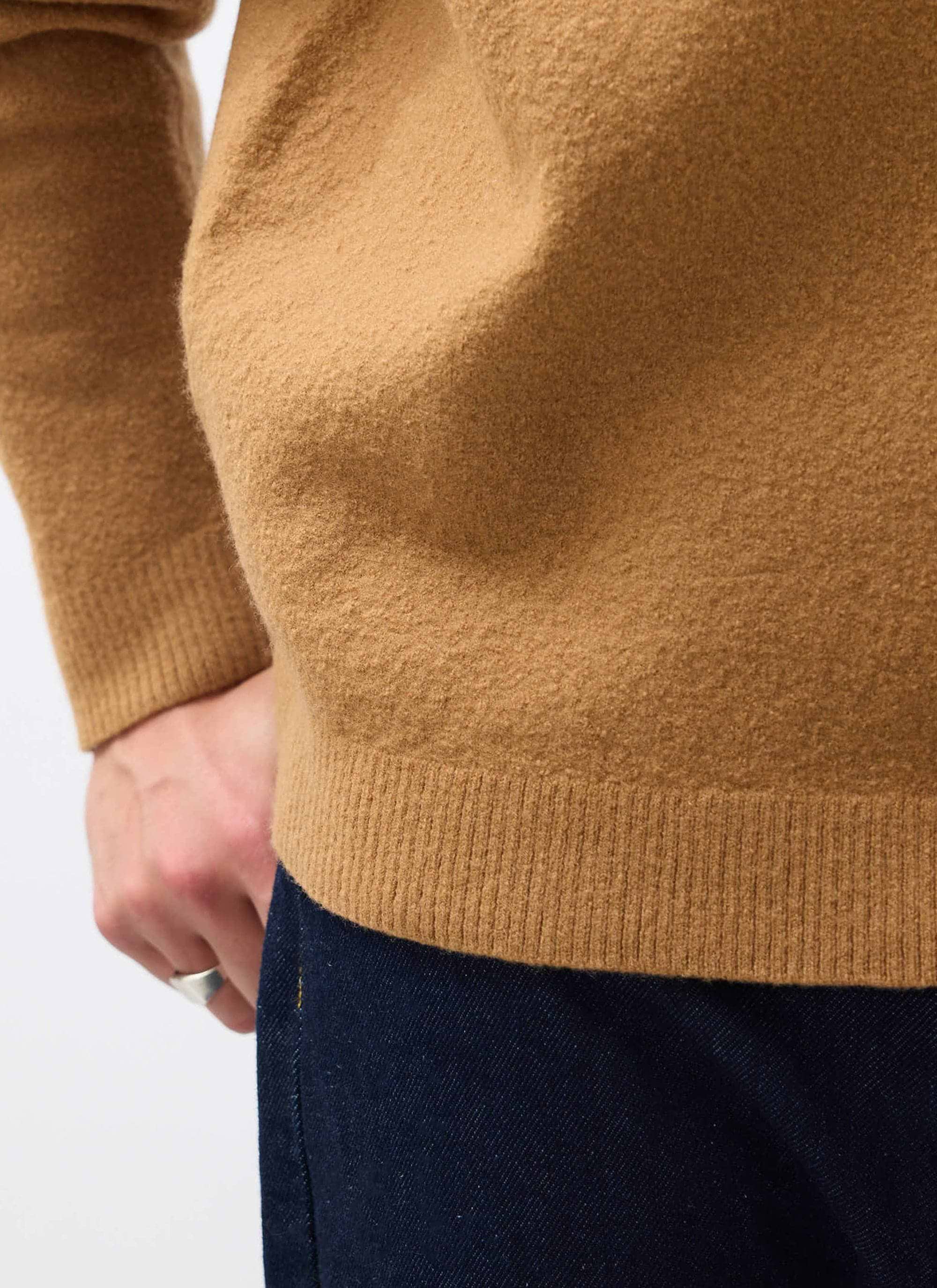A close-up of the Percival Felted Wool Jumper in brown, highlighting the soft, textured knit and ribbed hem.
