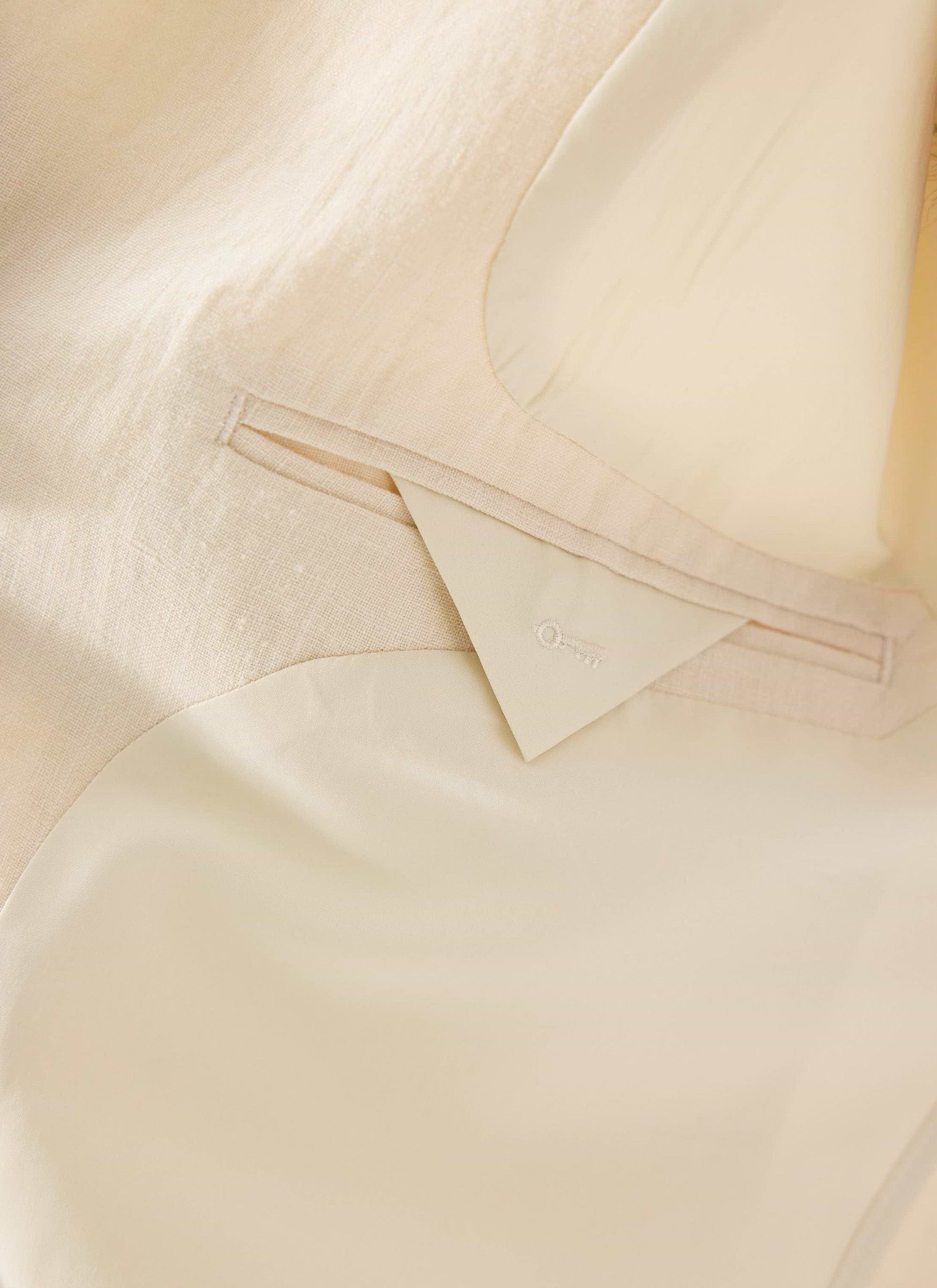 A close-up of the internal pocket and smart lining of the Percival Relaxed Linen Overshirt in stone.