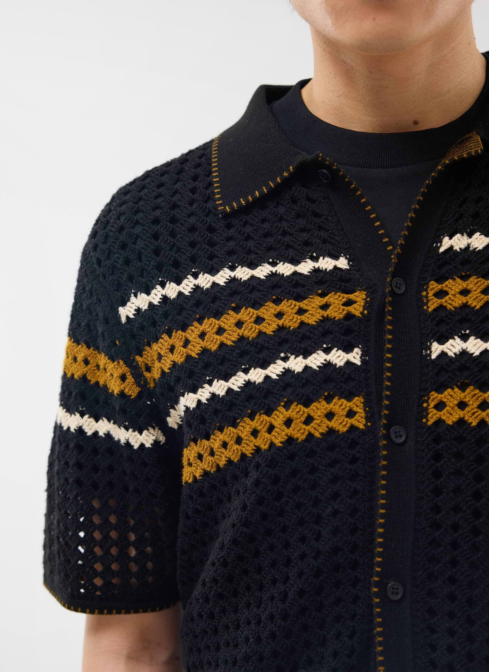 Detailed shot of the Percival Pesaro Knitted Shirt in black, showing the crochet knit, chest stripes and collar stitching.
