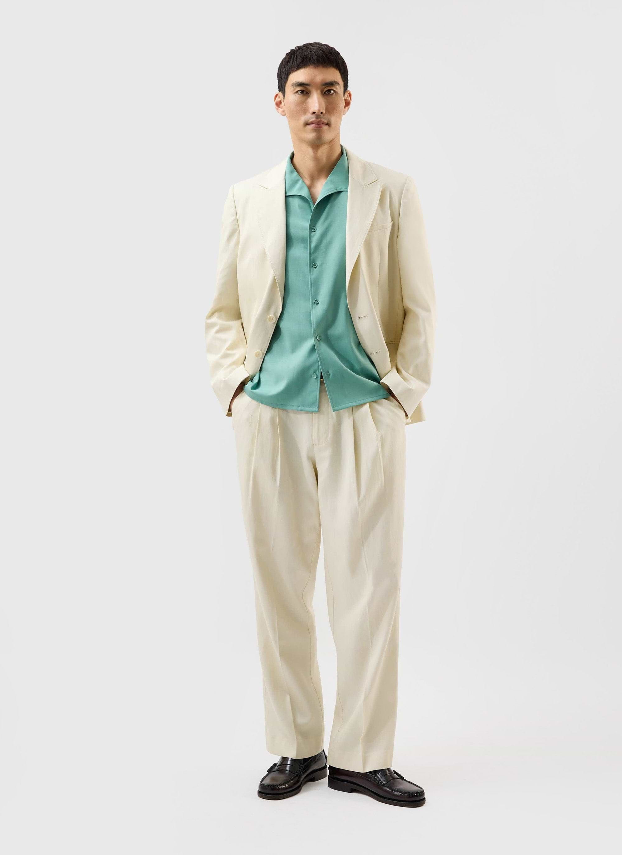 A model wears the Percival x Warren Drape Cuban Shirt in mint green, styled under an off-white suit.