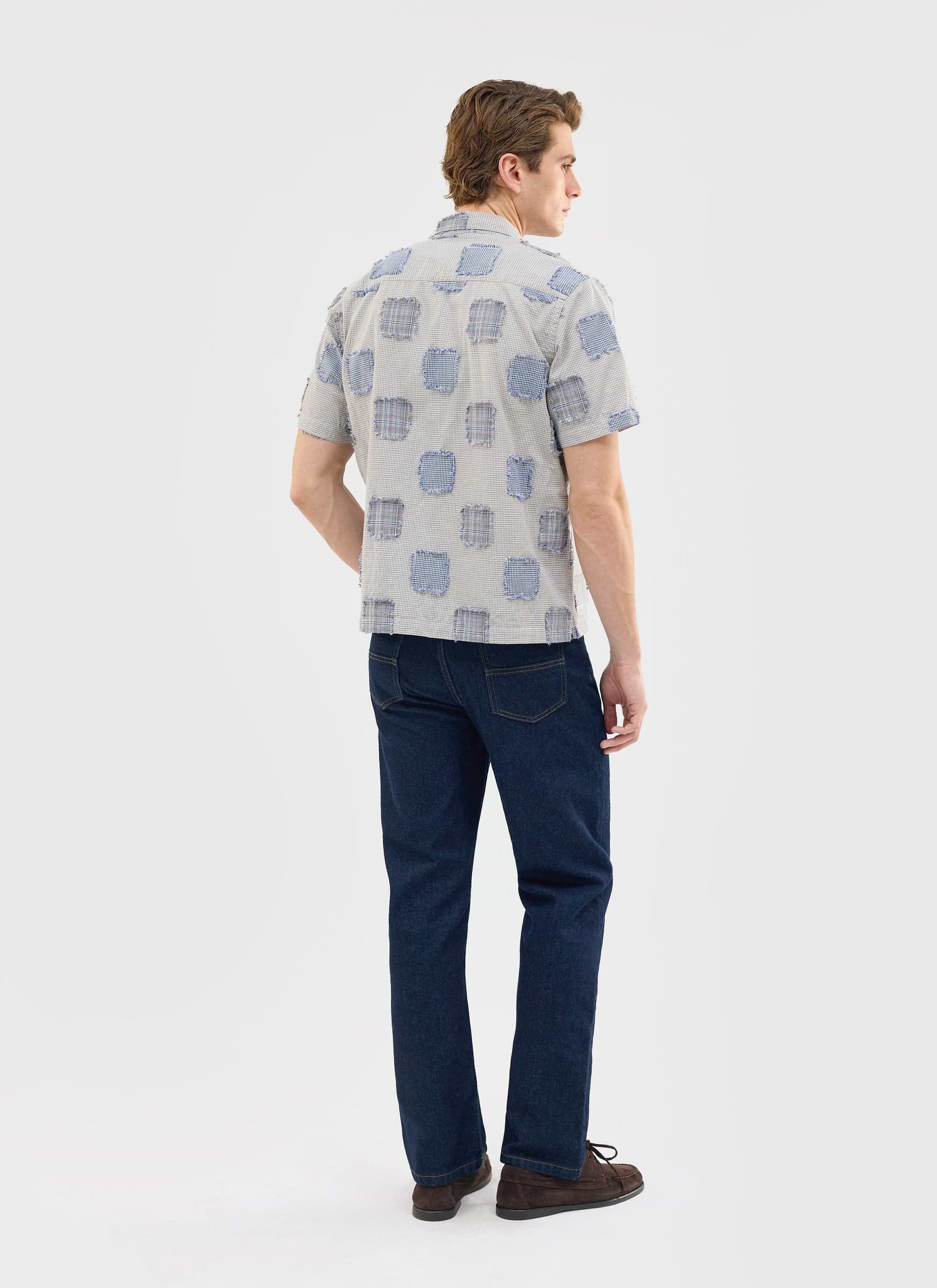 Back view of a model wearing the Percival Bruno Boxy Clerk Shirt in grey, showcasing the unique patchwork flannel design.
