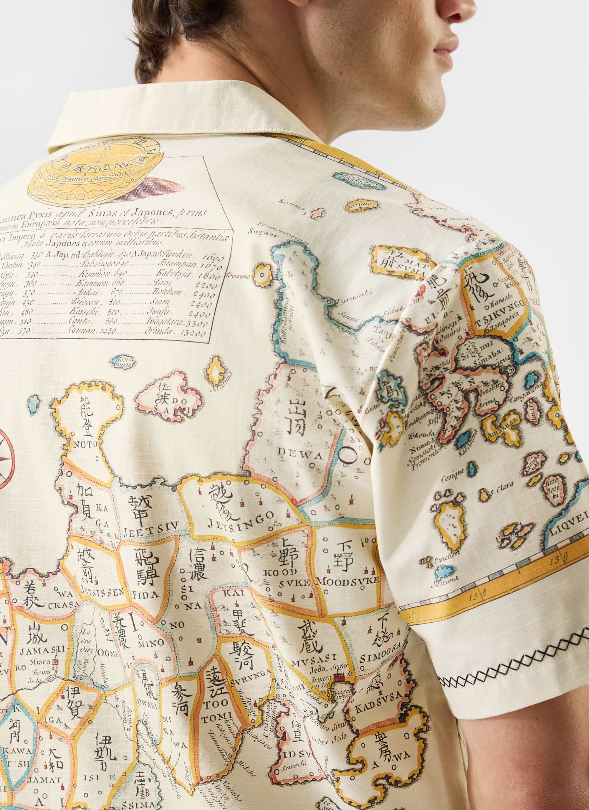 A close-up view of the intricate map artwork on the back of the ecru Ex Libris Cuban Shirt by Percival.