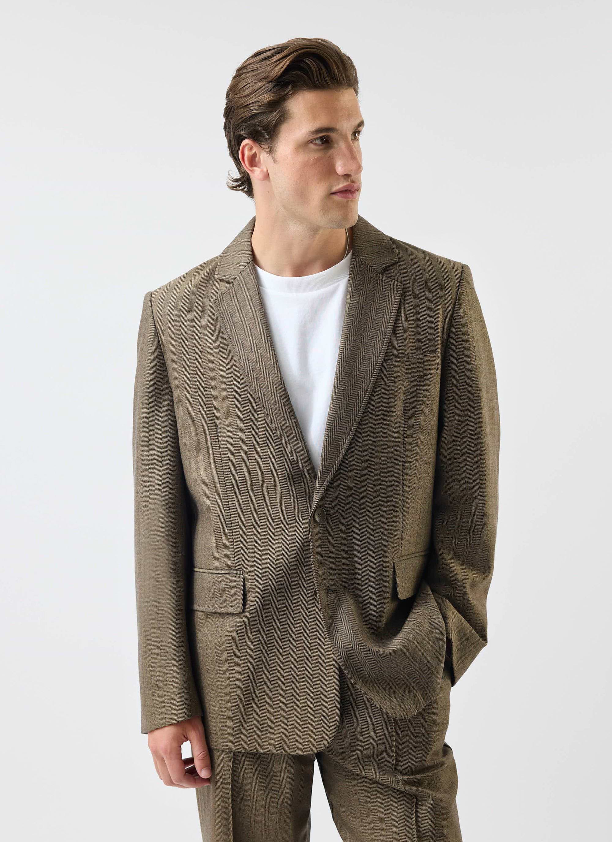 A model wears the Percival Grounds Tailored Blazer and matching trousers in oak herringbone wool on a white background.