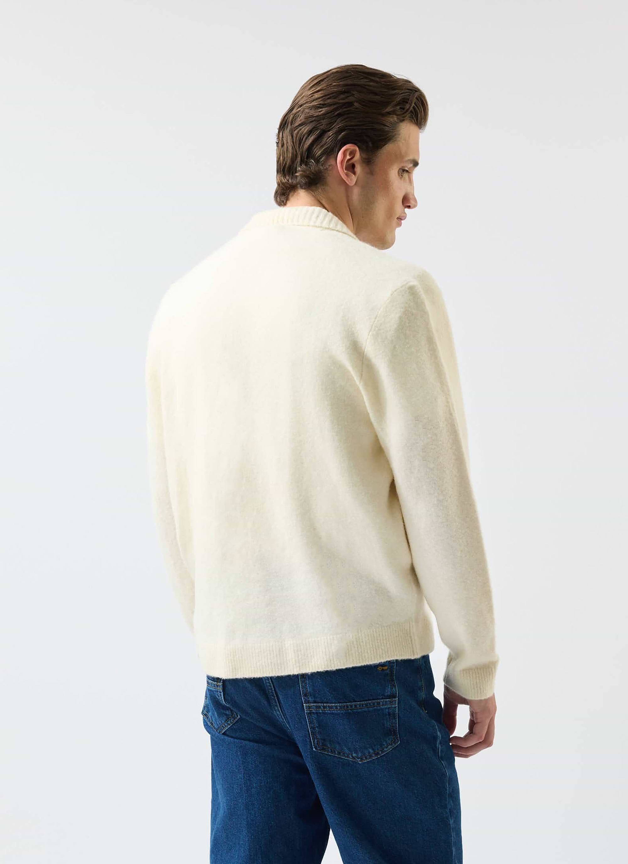 Back view of a man modelling the Percival Archive Wool Knitted Collared Cardigan in ecru cream against a white background.