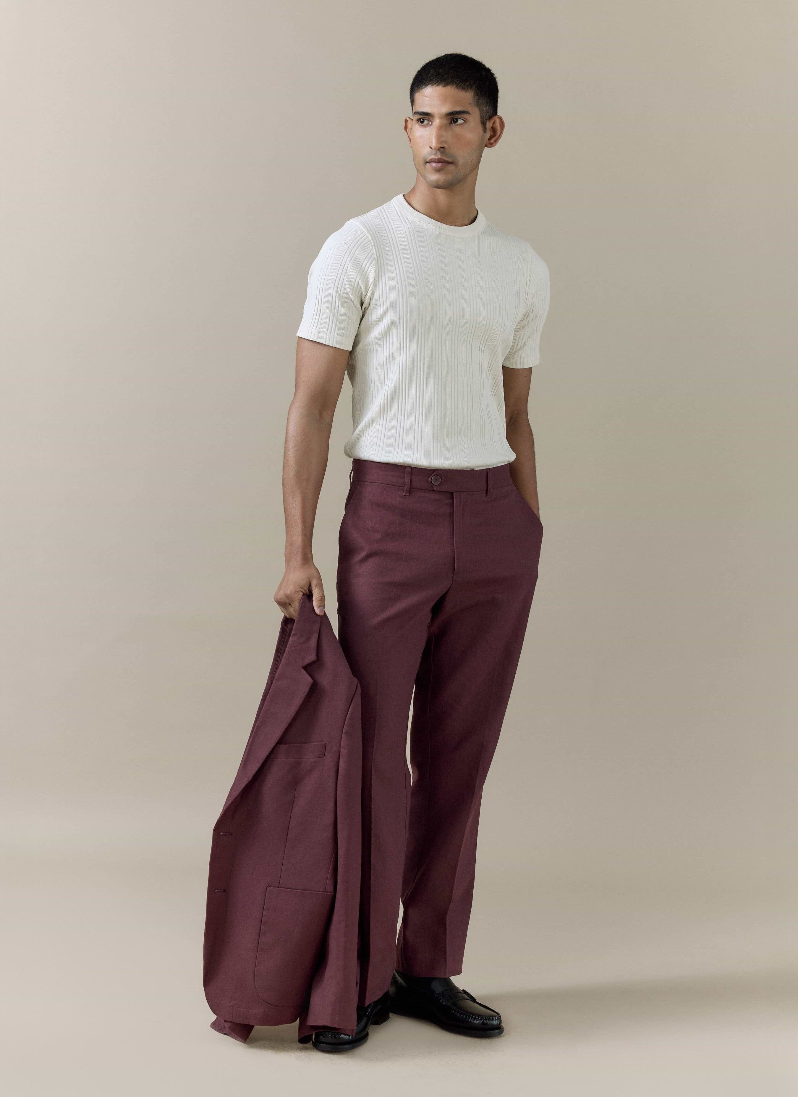 Percival tailored linen trousers in merlot worn with a white ribbed top and matching blazer held by a model.