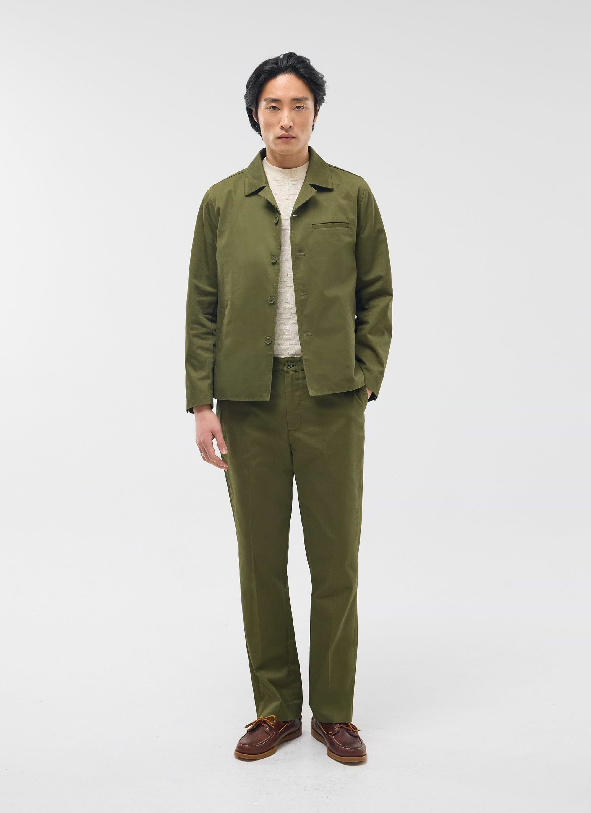 The Percival Casual Workwear Jacket in khaki cotton, styled on a model with matching trousers and a cream jumper.