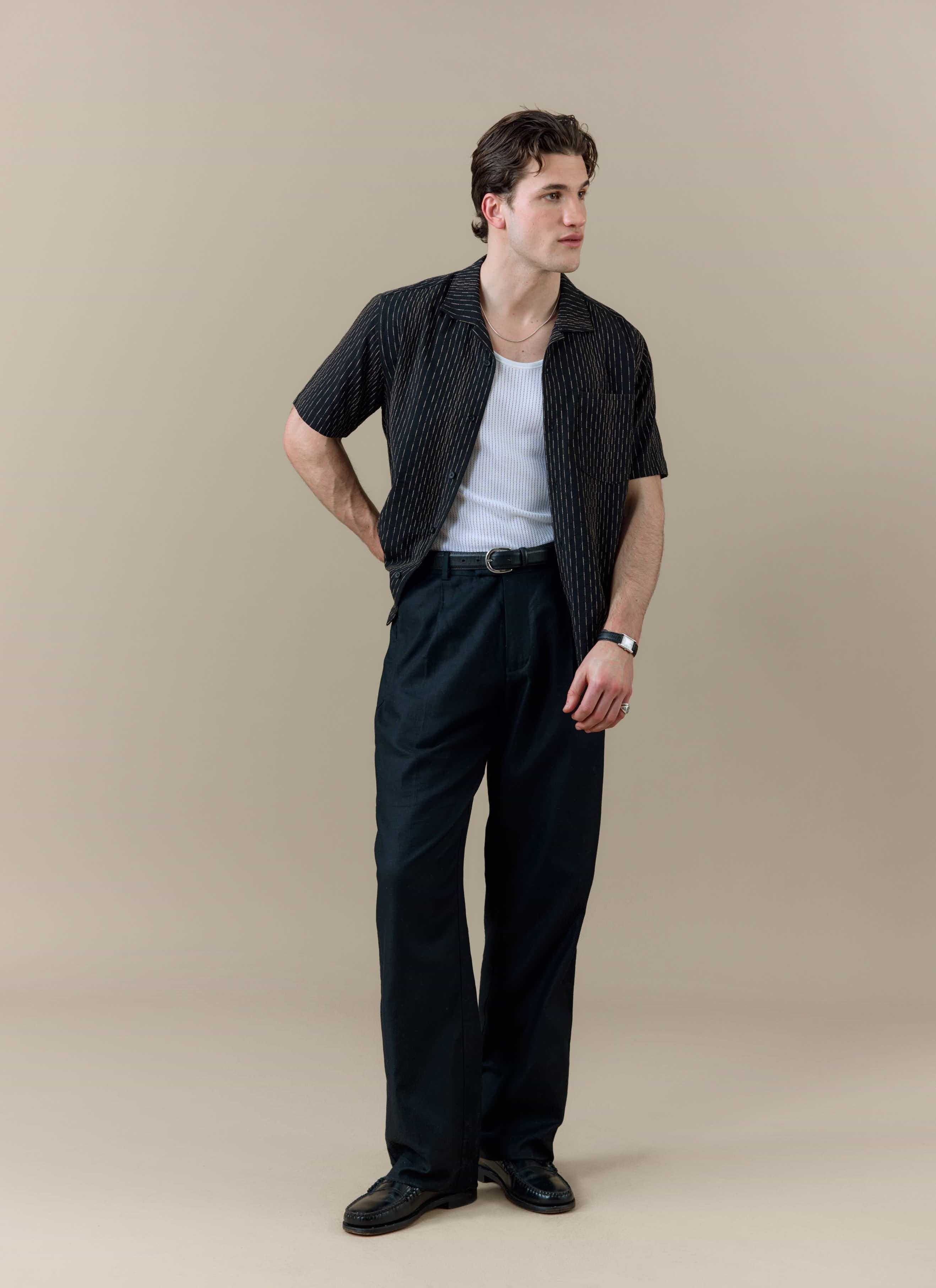 Model wearing the black Percival Leland Cuban Shirt with vertical stripe detailing and a classic Cuban collar.