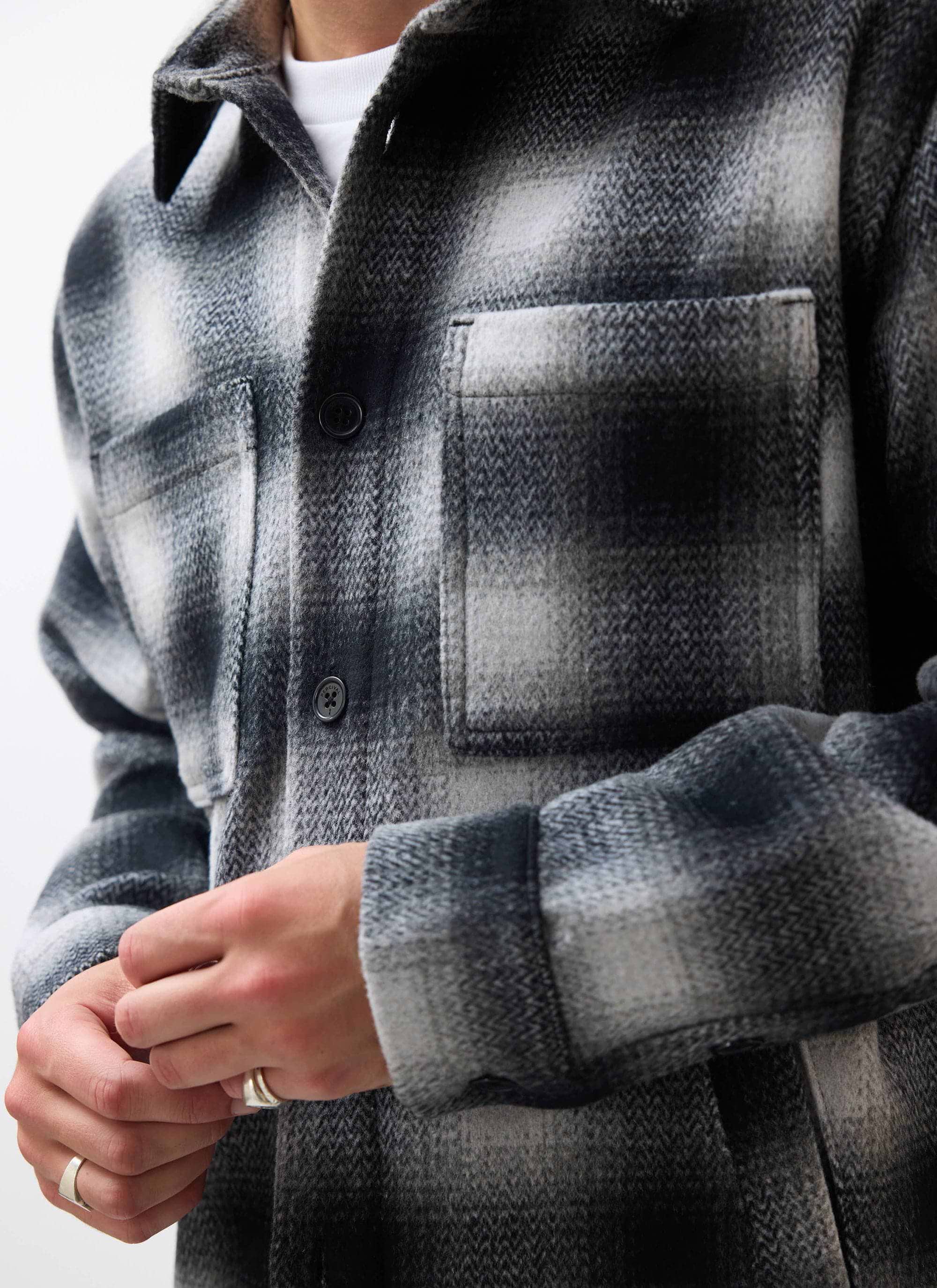 Close up of a model wearing the Percival Check Overshirt in grey, showing the brushed wool blend texture and chest pocket.