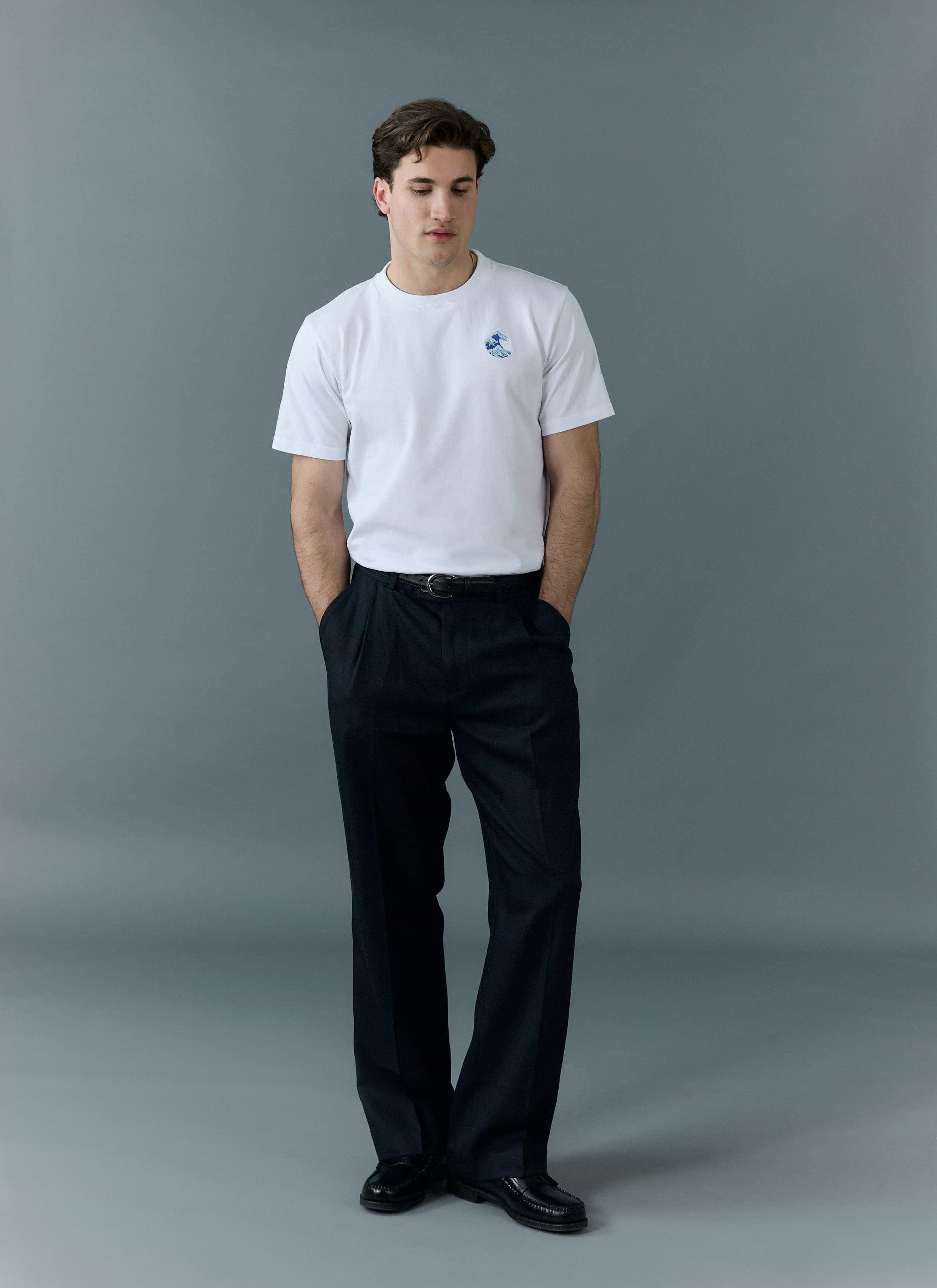 Percival Wave T Shirt in white, an embroidered organic cotton tee, styled on a model with black trousers and loafers.