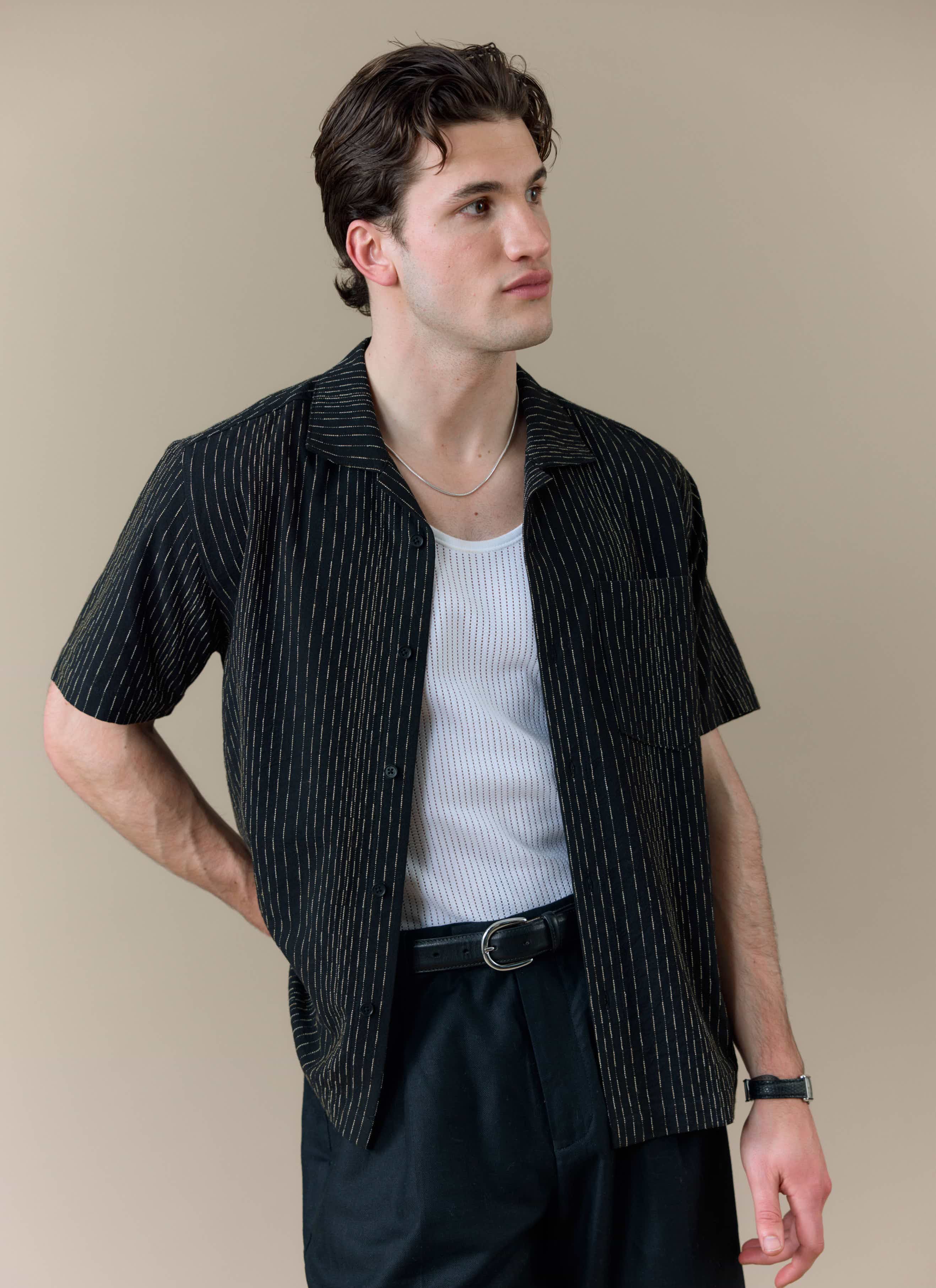 Model wearing the black Leland Cuban shirt by Percival, showing the subtle vertical stripe detail and Cuban collar.