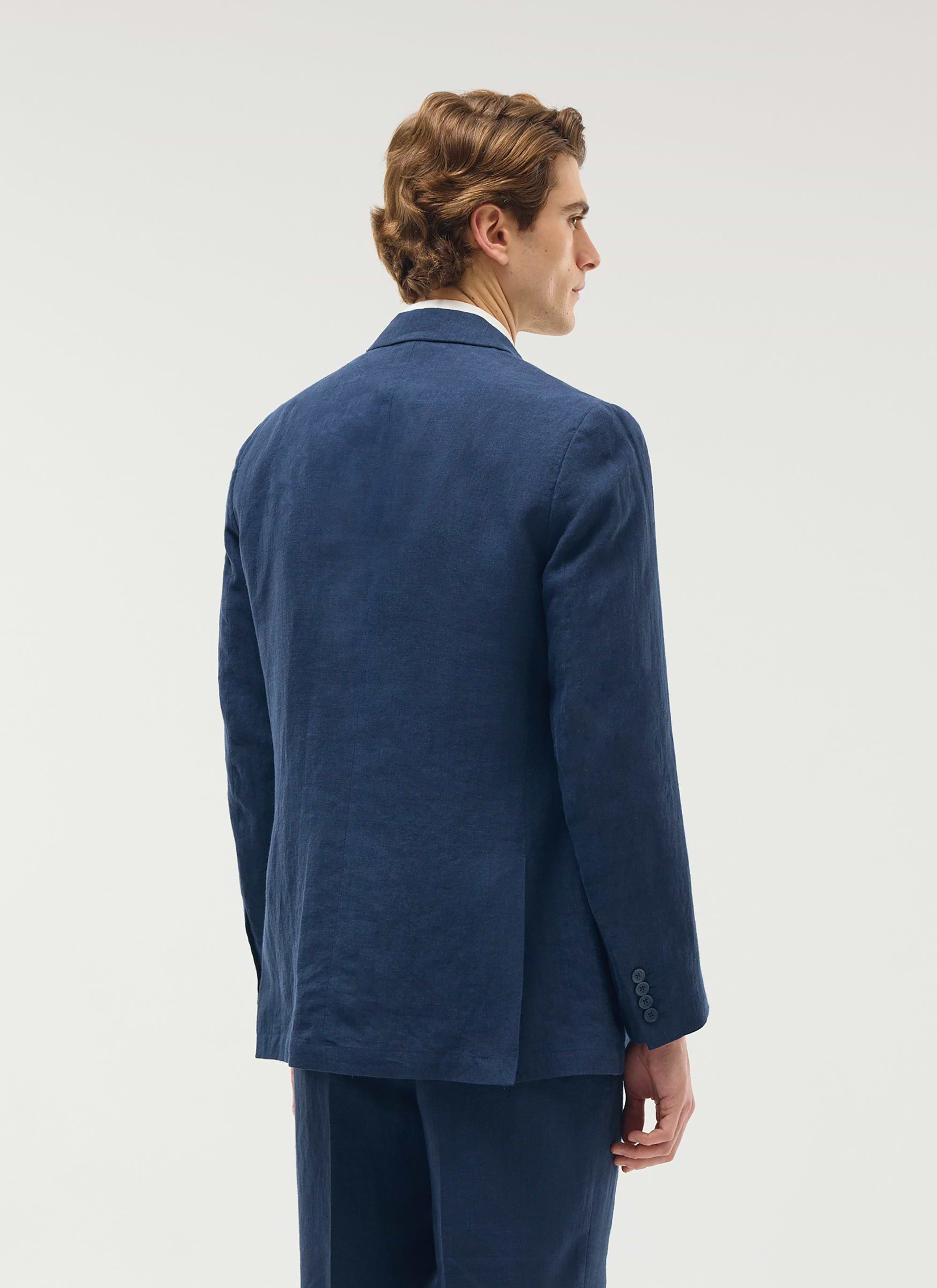 Back view of a model wearing the Percival tailored double breasted linen blazer in navy.