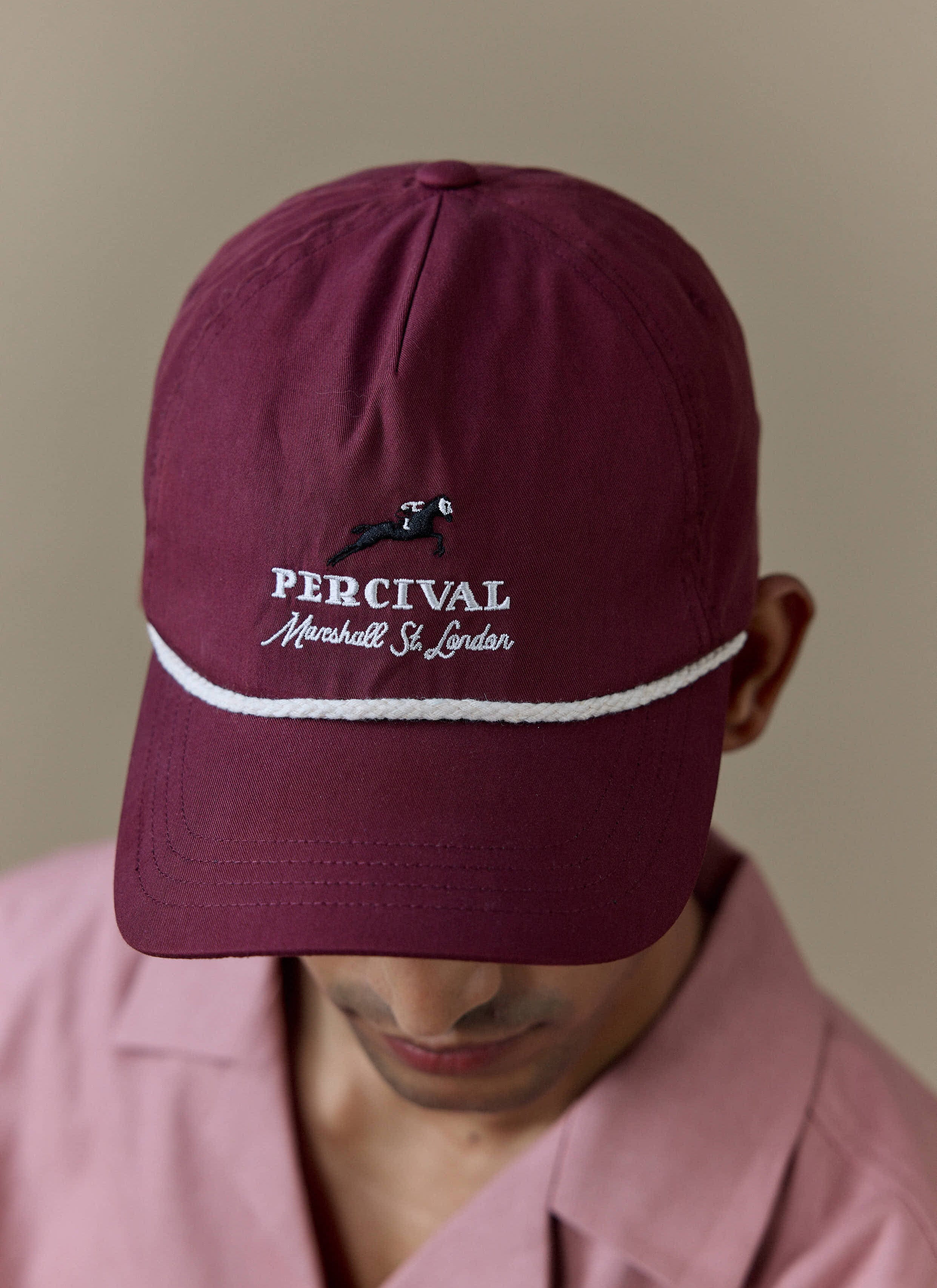Close-up of the red Percival Tournament Soft Trucker Cap, featuring white rope detail and Marshall St. London embroidery.