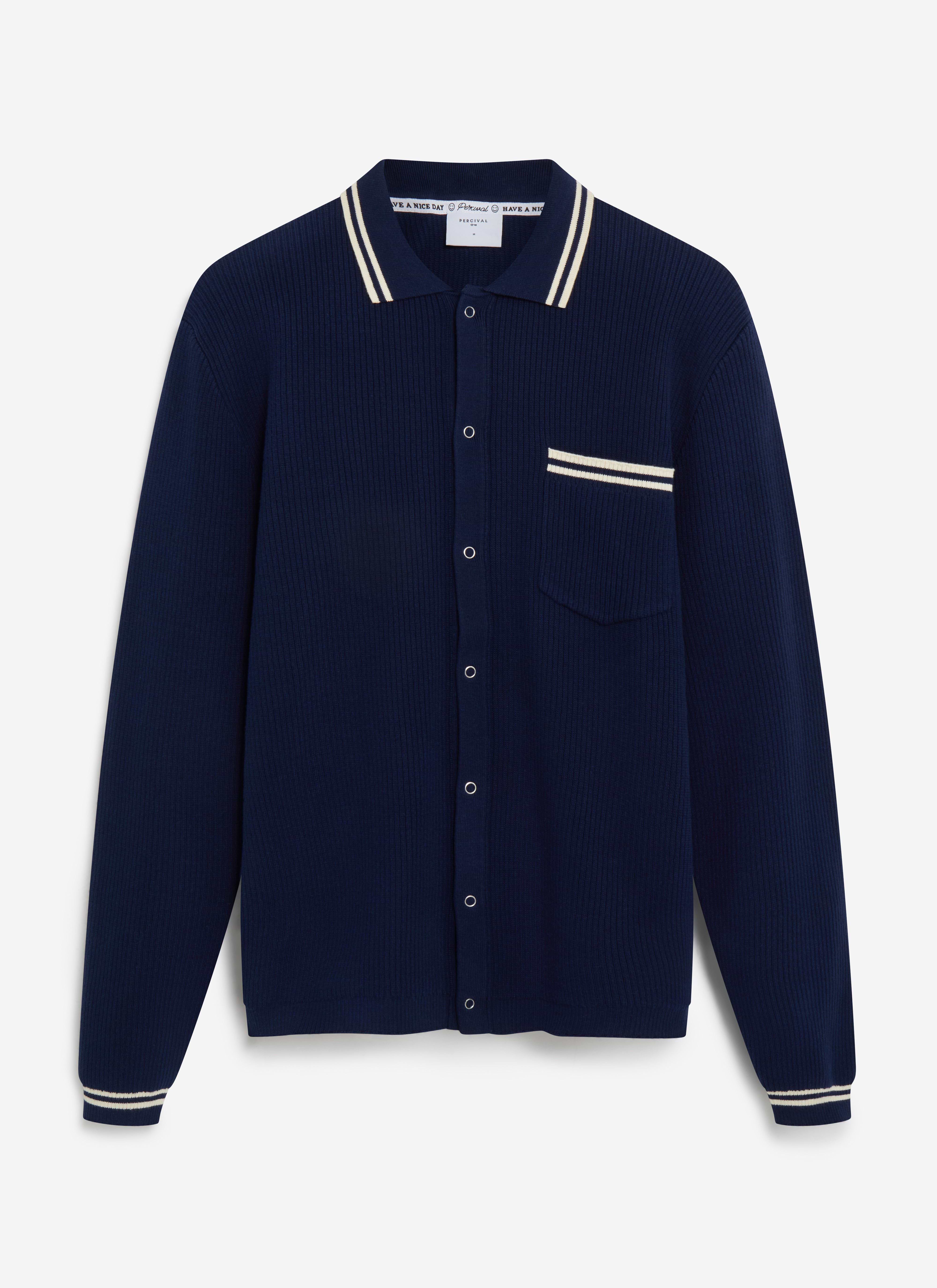 The Percival Pablo long-sleeve knitted shirt in navy, laid flat, showing its ribbed texture and cream tipping details.