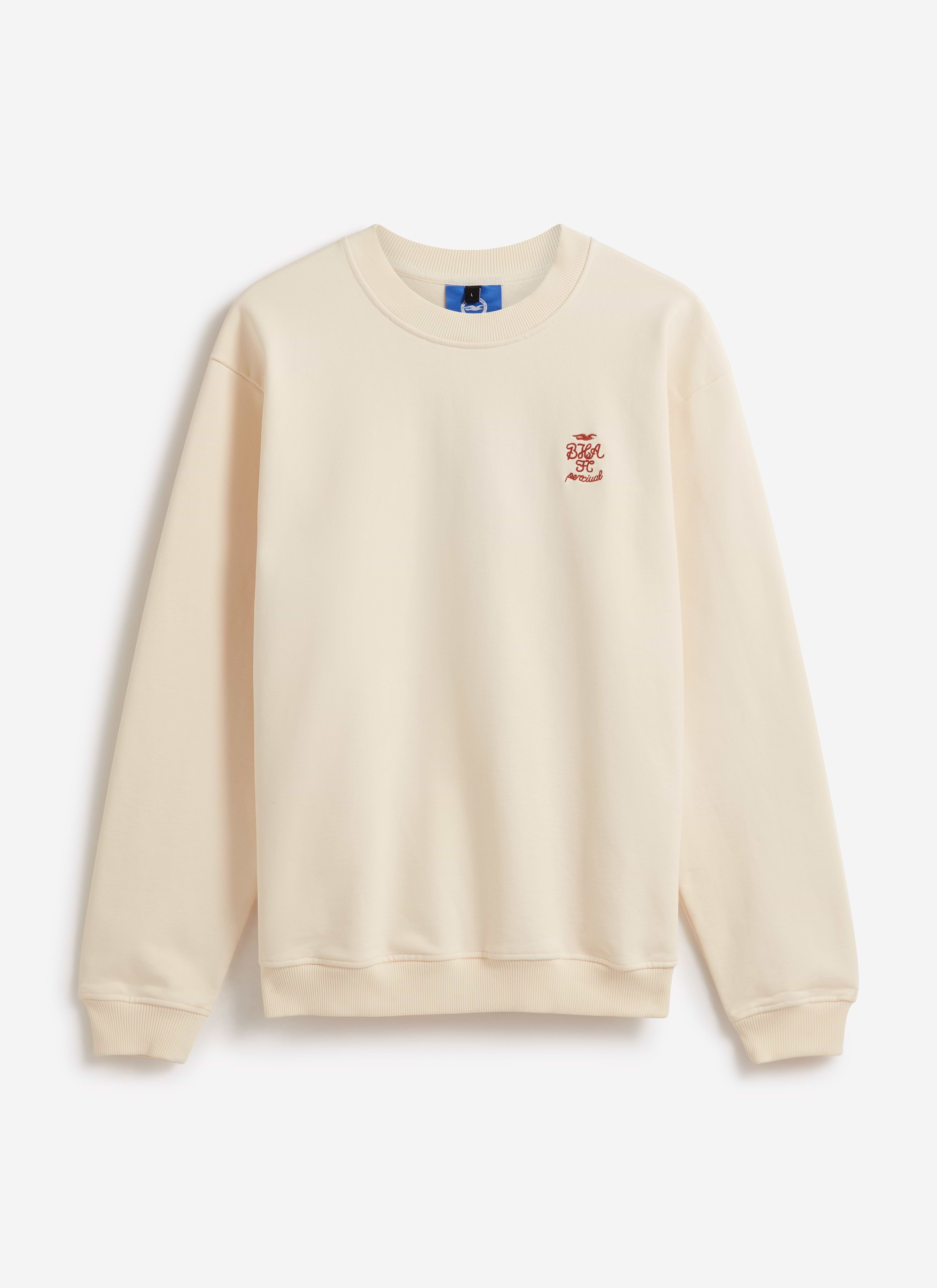 Front view of the cream Percival x Brighton & Hove Albion F.C. sweatshirt, showing the red chest crest embroidery.