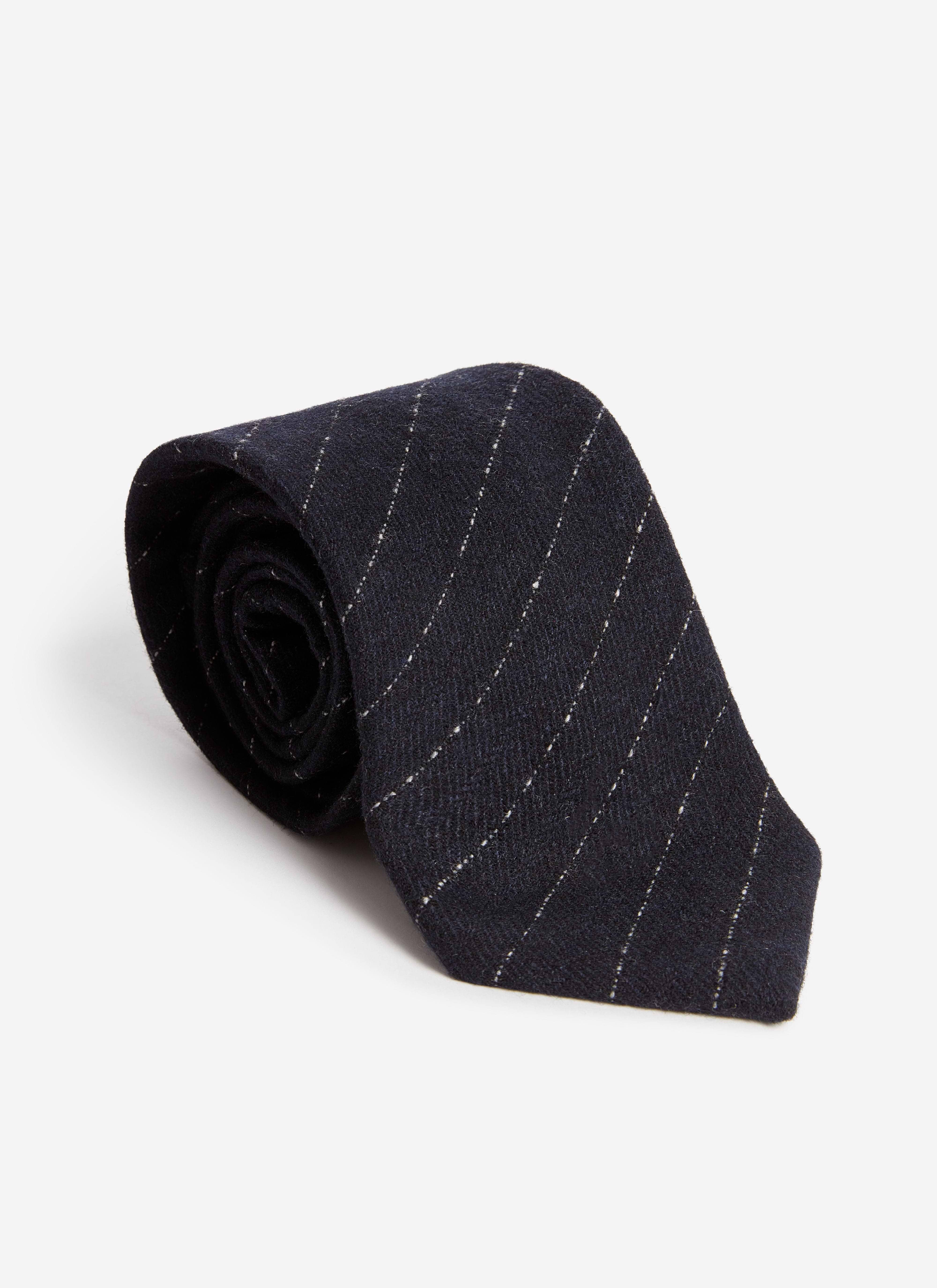 The Percival Textured Stripe Tie in navy, a cotton-blend tie with a diagonal stripe, rolled up on a white background.