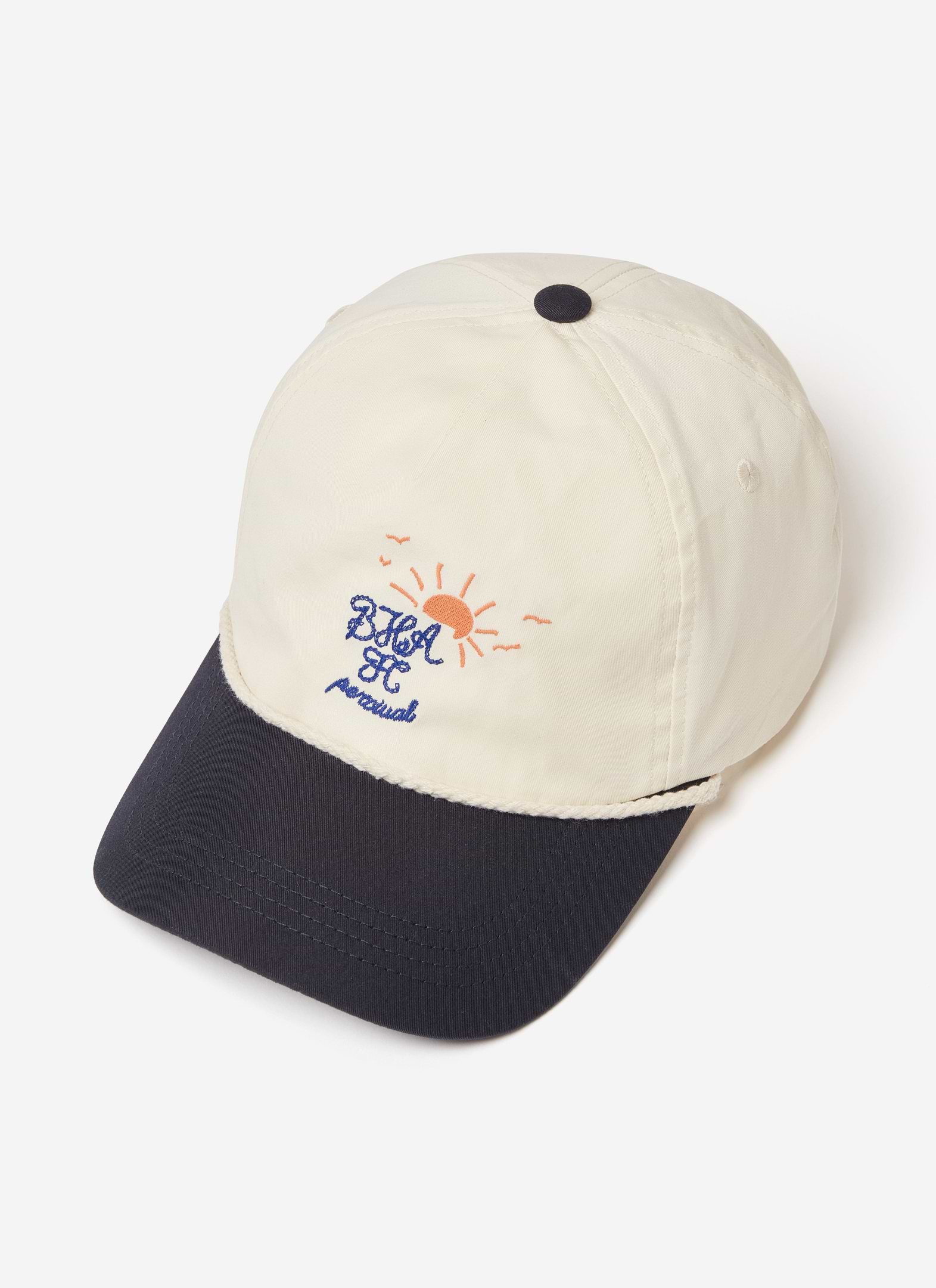A cream and navy Brighton & Hove Albion F.C. x Percival trucker cap with sun embroidery and rope detail.