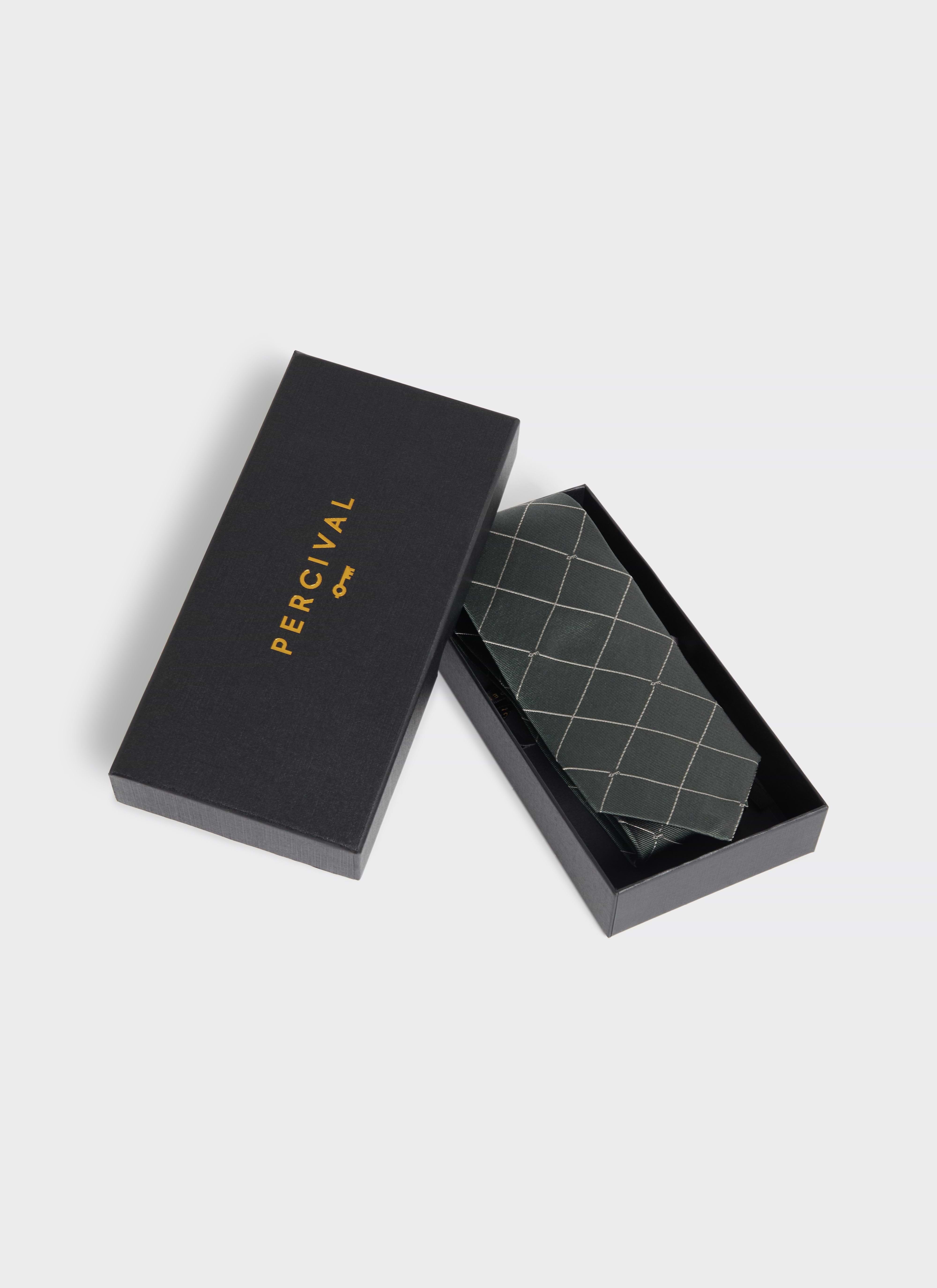 The Percival Window Pane Key Jacquard Tie in forest green silk, shown folded inside a branded black gift box.