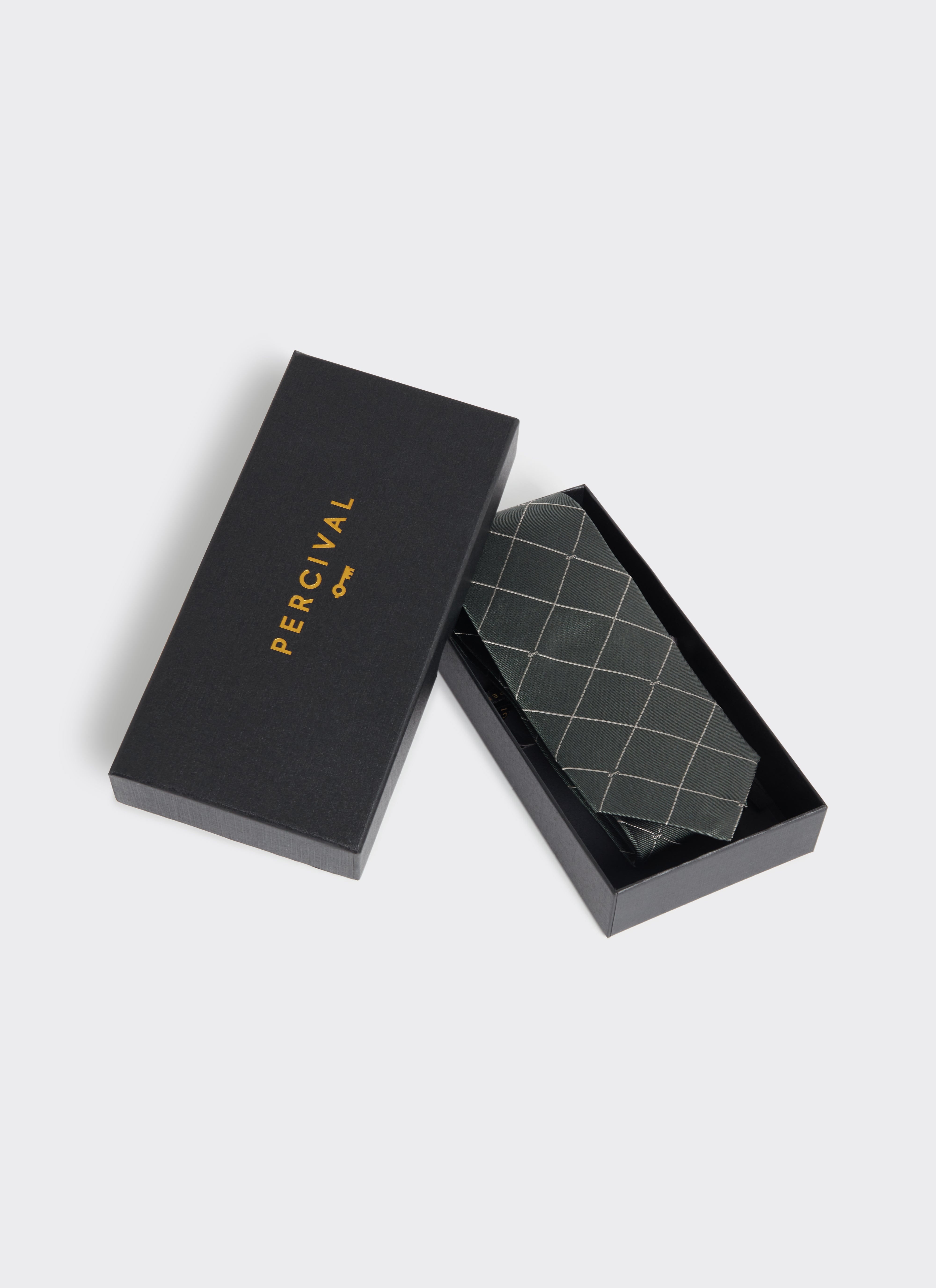 The Percival Window Pane Key Jacquard Tie in forest green silk, shown folded inside a branded black gift box.