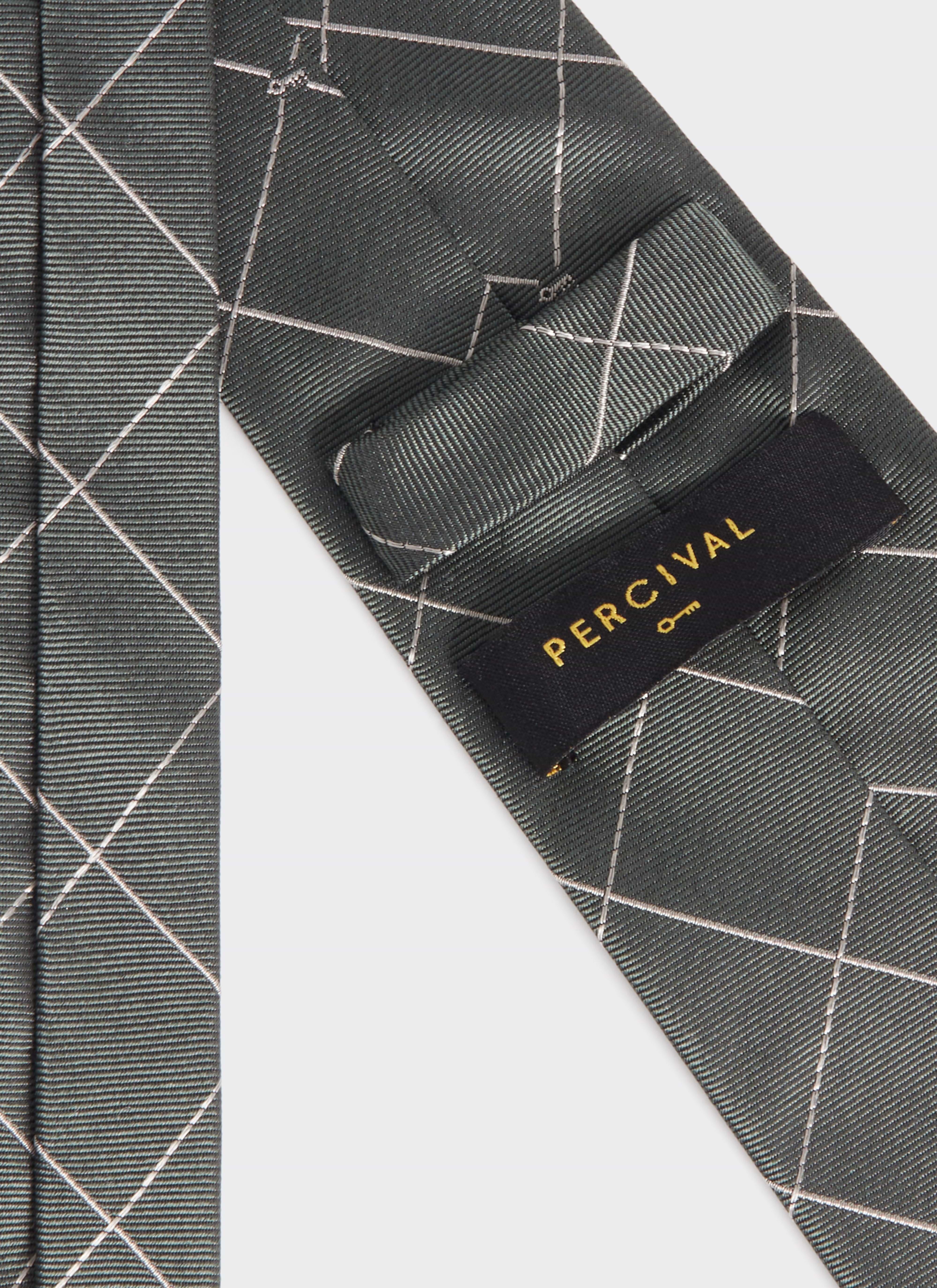 Close-up of the forest green silk Window Pane Key Jacquard Tie by Percival, showing the brand label and grid pattern.