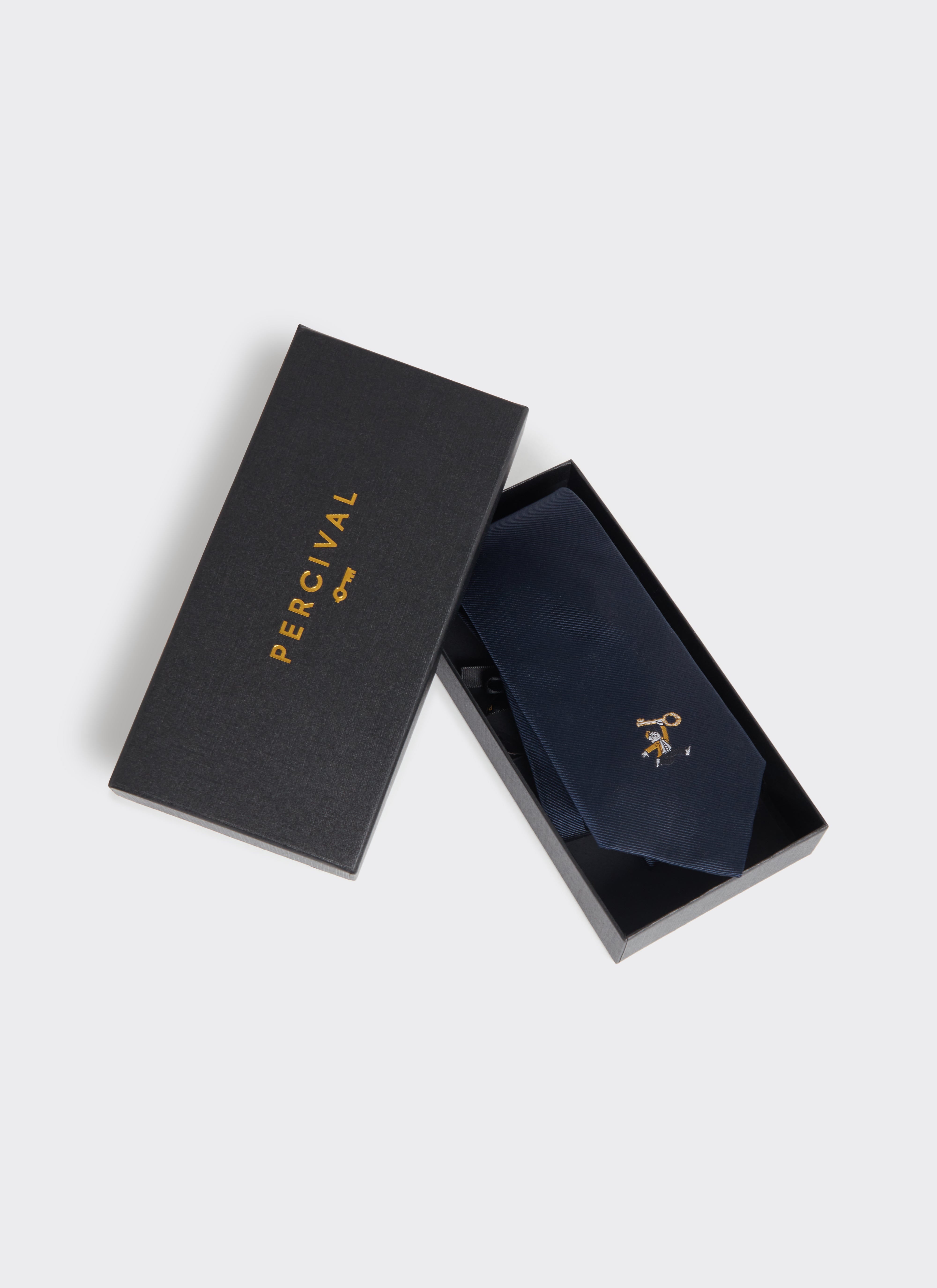 Navy silk Percival World Key Tie with embroidered motif, displayed in a black branded gift box.