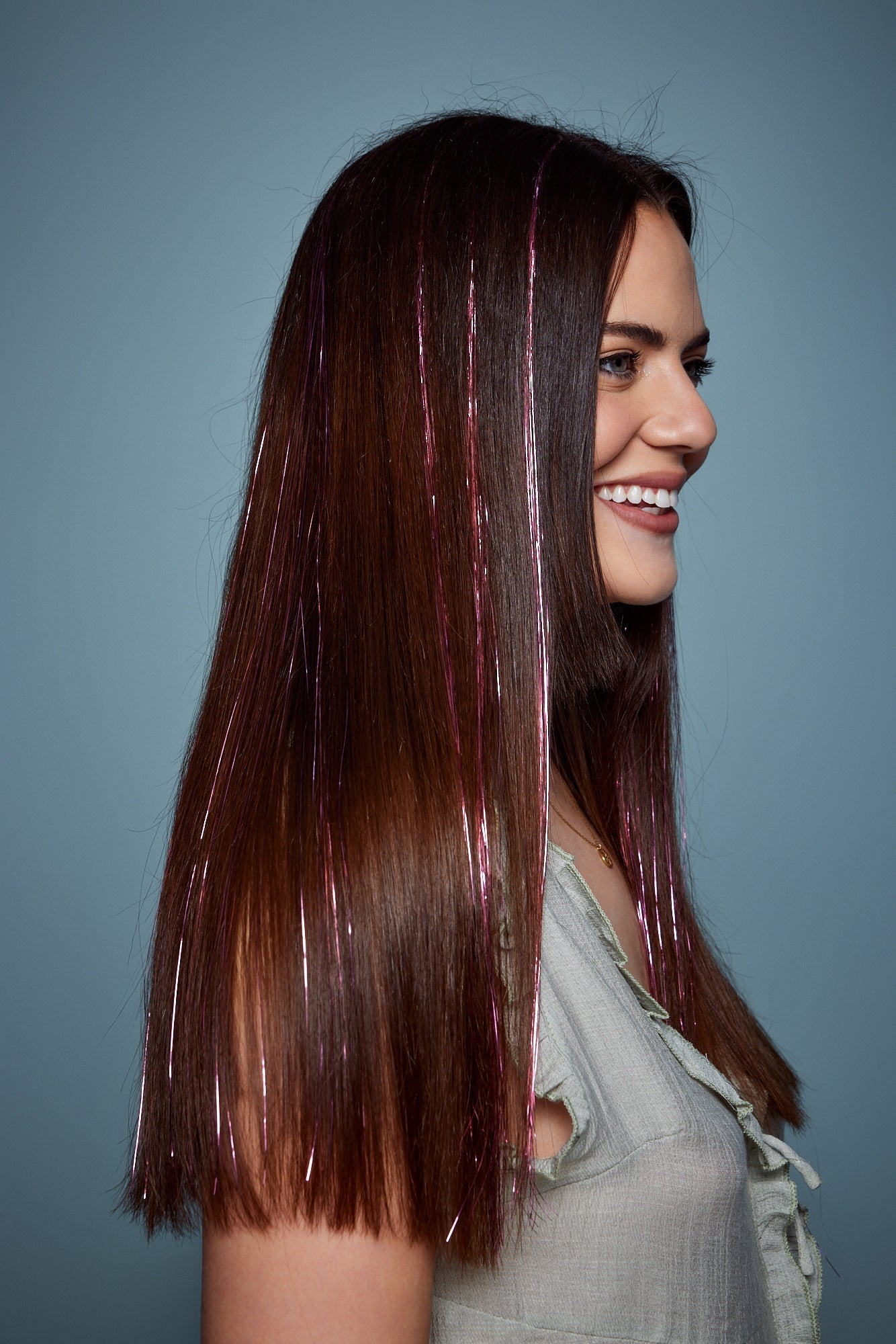 מדיום שוט של בחורה שבשיער שלה שזורים חוטי טינסל בצבעי ורוד זוהר - הנקראים אצלנו גווני פיות. מיועדים לחיבור עצמאי, פשוט וקבוע לשיער או לחיבור זמני - Shufizoo