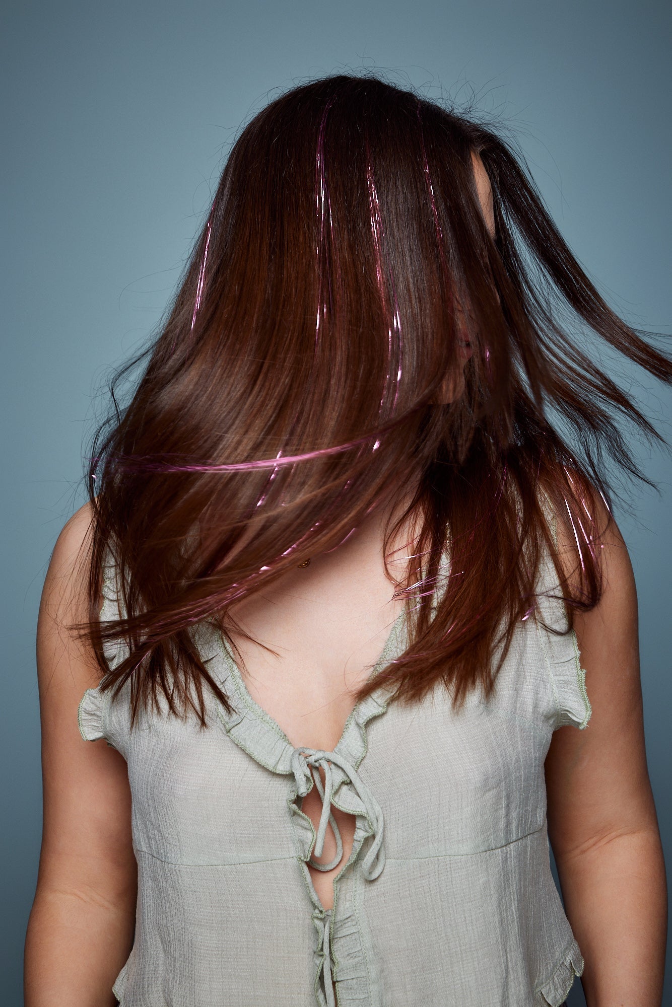 מדיום שוט של בחורה שבשיער שלה שזורים חוטי טינסל בצבעי ורוד זוהר - הנקראים אצלנו גווני פיות. מיועדים לחיבור עצמאי, פשוט וקבוע לשיער או לחיבור זמני - Shufizoo