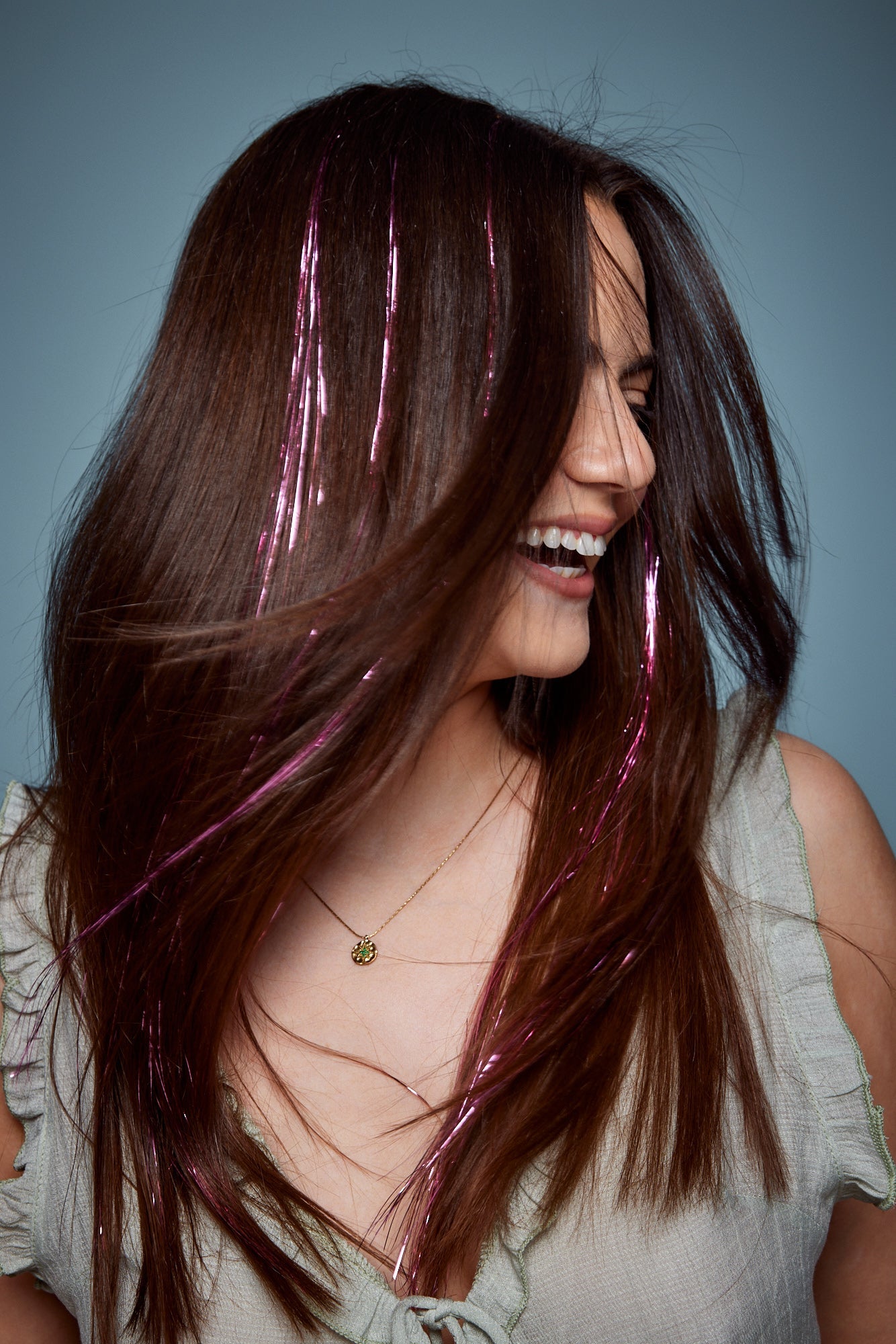 קלוז אפ של בחורה שבשיער שלה שזורים חוטי טינסל בצבעי ורוד זוהר - הנקראים אצלנו גווני פיות. מיועדים לחיבור עצמאי, פשוט וקבוע לשיער או לחיבור זמני - Shufizoo