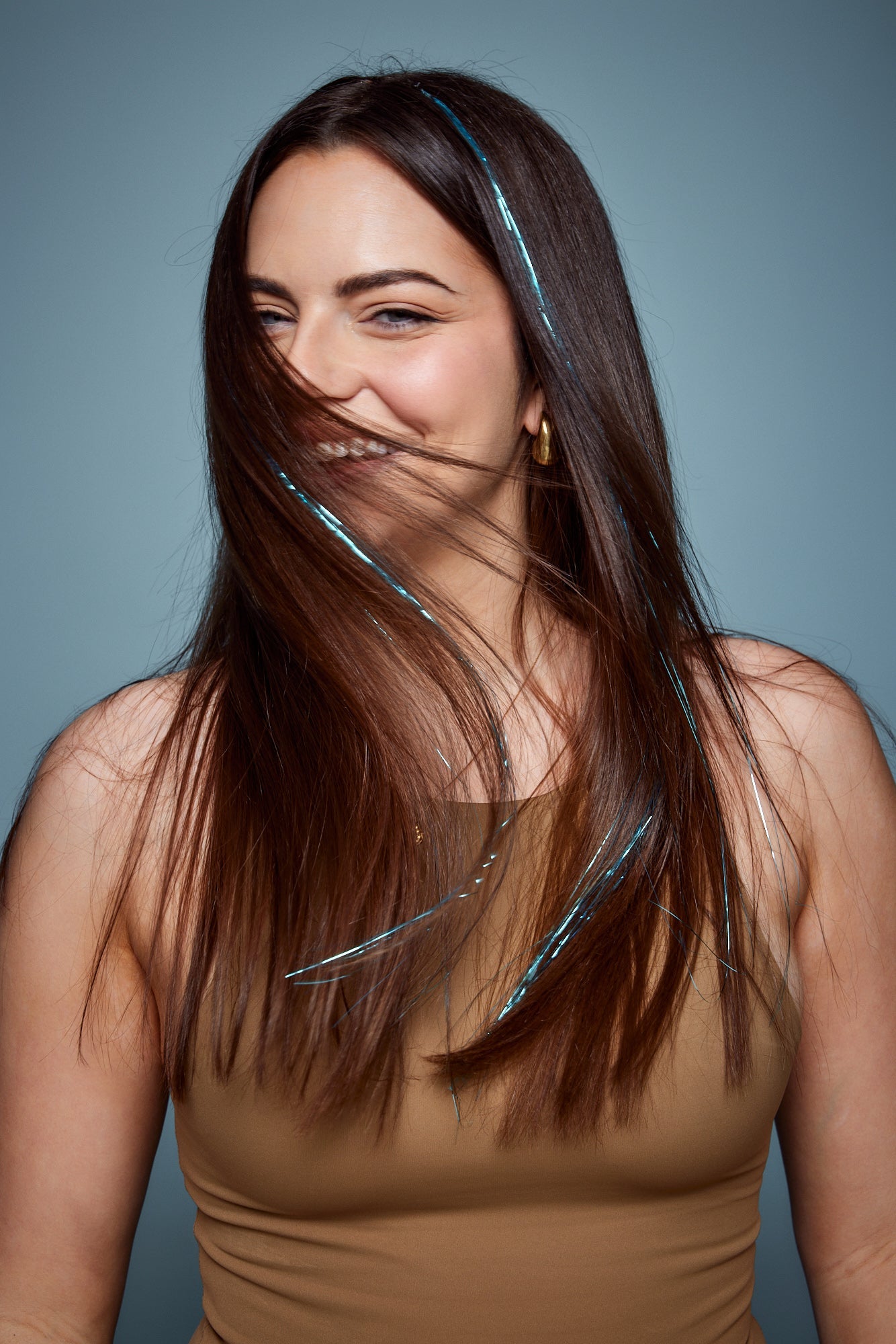 מדיום שוט של בחורה שבשיער שלה שזורים חוטי טינסל בצבעי כחול בהיר זוהר - הנקראים אצלנו גווני פיות. מיועדים לחיבור עצמאי, פשוט וקבוע לשיער או לחיבור זמני - Shufizoo