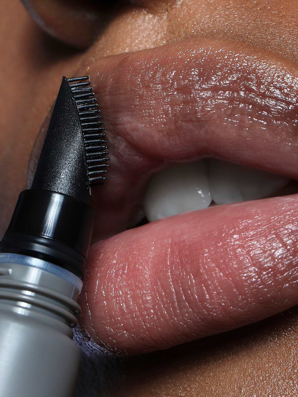 CLOSE UP OF MODEL USING REFY LIP BUFF ON LIPS