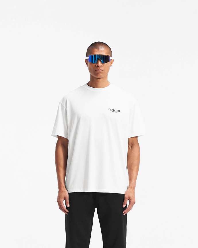 Man wearing a white oversized t-shirt on a plain white background | Team 247 Oversized T-Shirt in Flat White | Gym top with quick dry fabric and Team 247 branding | 247 T-Shirts | Represent Clo