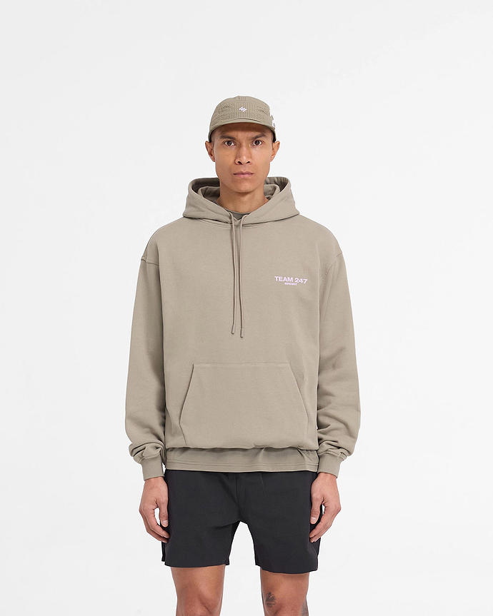 Man wearing a khaki lilac oversized hoodie on a plain white background | Team 247 Oversized Hoodie in Khaki Lilac | Heavyweight jersey hoodie with Team 247 branding | 247 Hoodies | Represent Clo