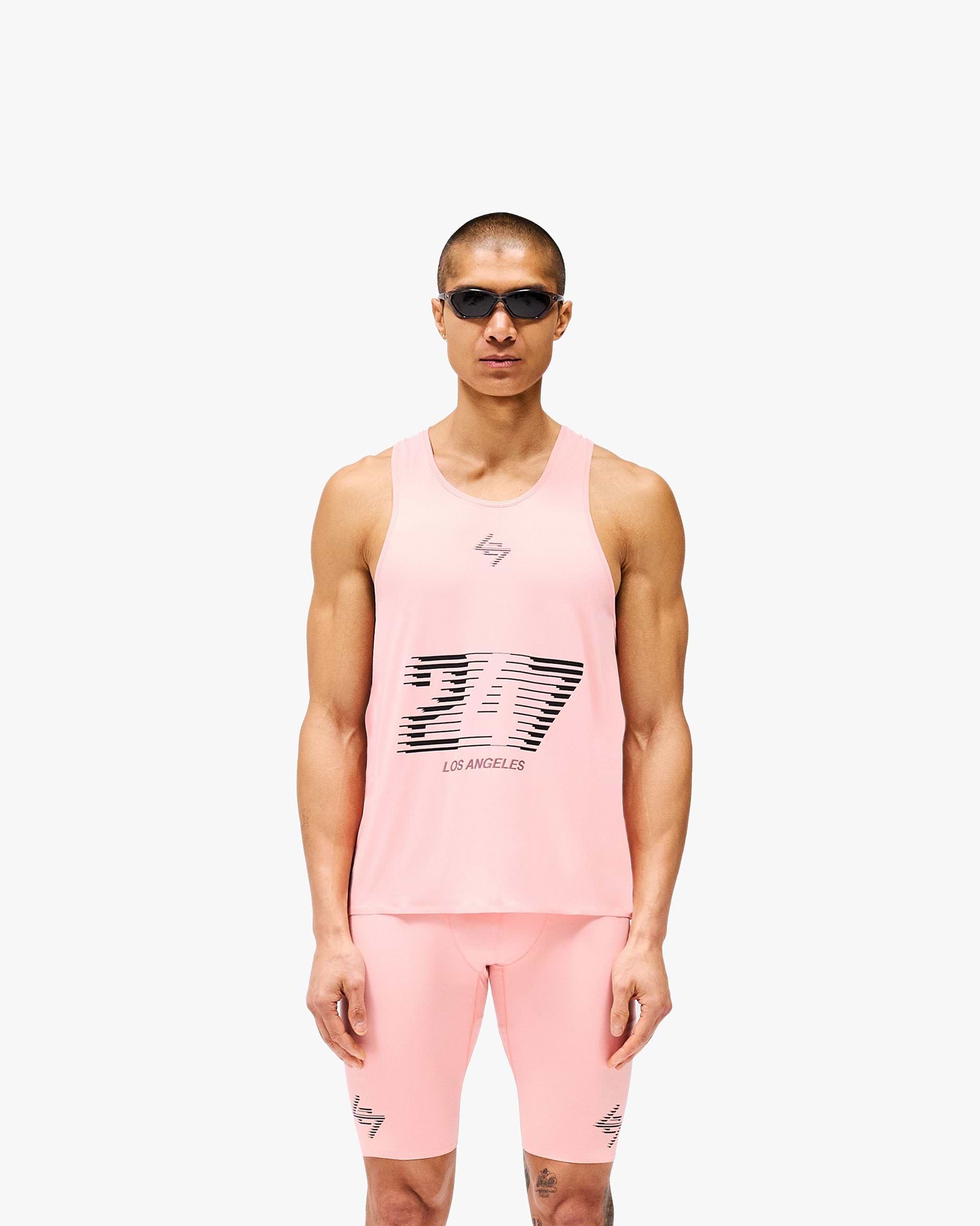 Man wearing a pink singlet on a plain white background | 247 Los Angeles Singlet in Pink | Lightweight breathable racerback singlet with mesh back | 247 T-Shirts | Represent Clo
