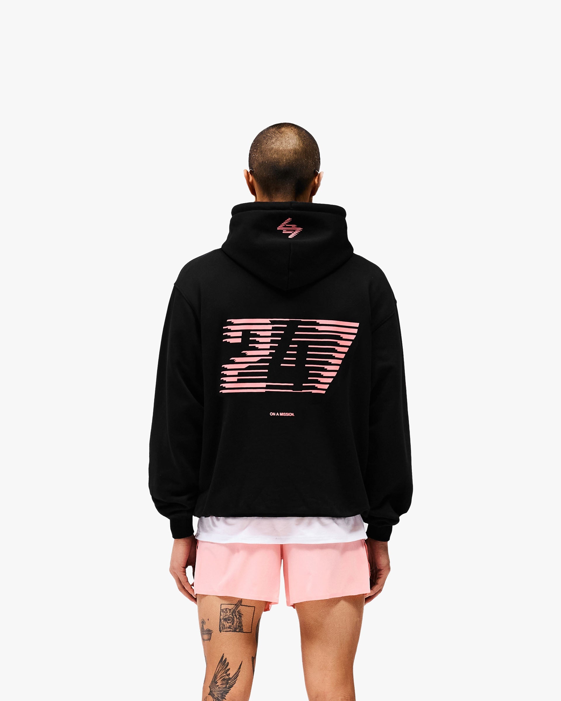 Man wearing an oversized black hoodie on a plain white background | 247 Los Angeles Hoodie in Jet Black | Hoodie with ribbed cuffs and Los Angeles graphic | 247 Hoodies | Represent Clo