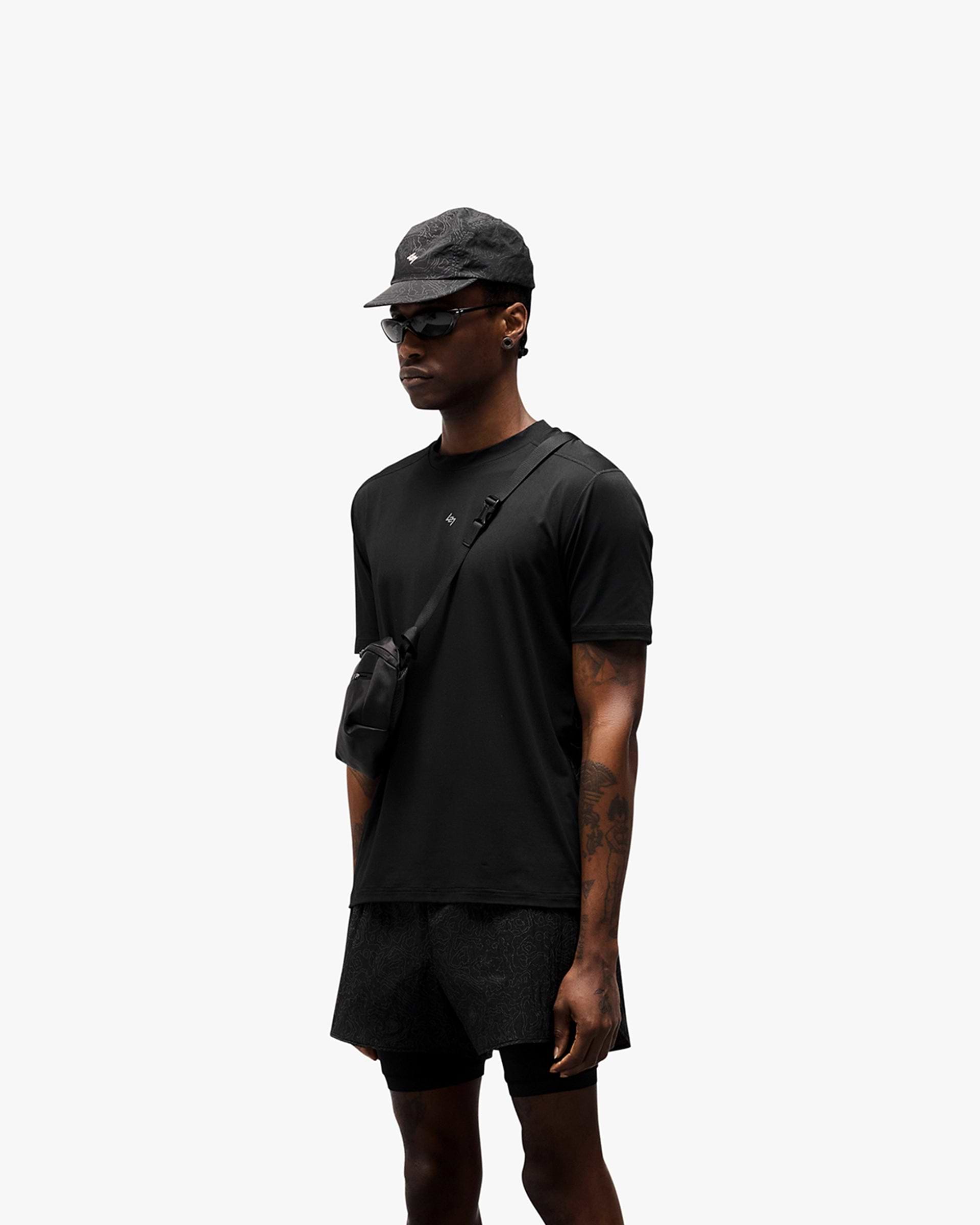 Man wearing a black t-shirt with reflective contour print on a plain white background | 247 Contour Run T-Shirt in Black | Breathable running t-shirt with antibacterial finish | 247 T-Shirts | Represent Clo