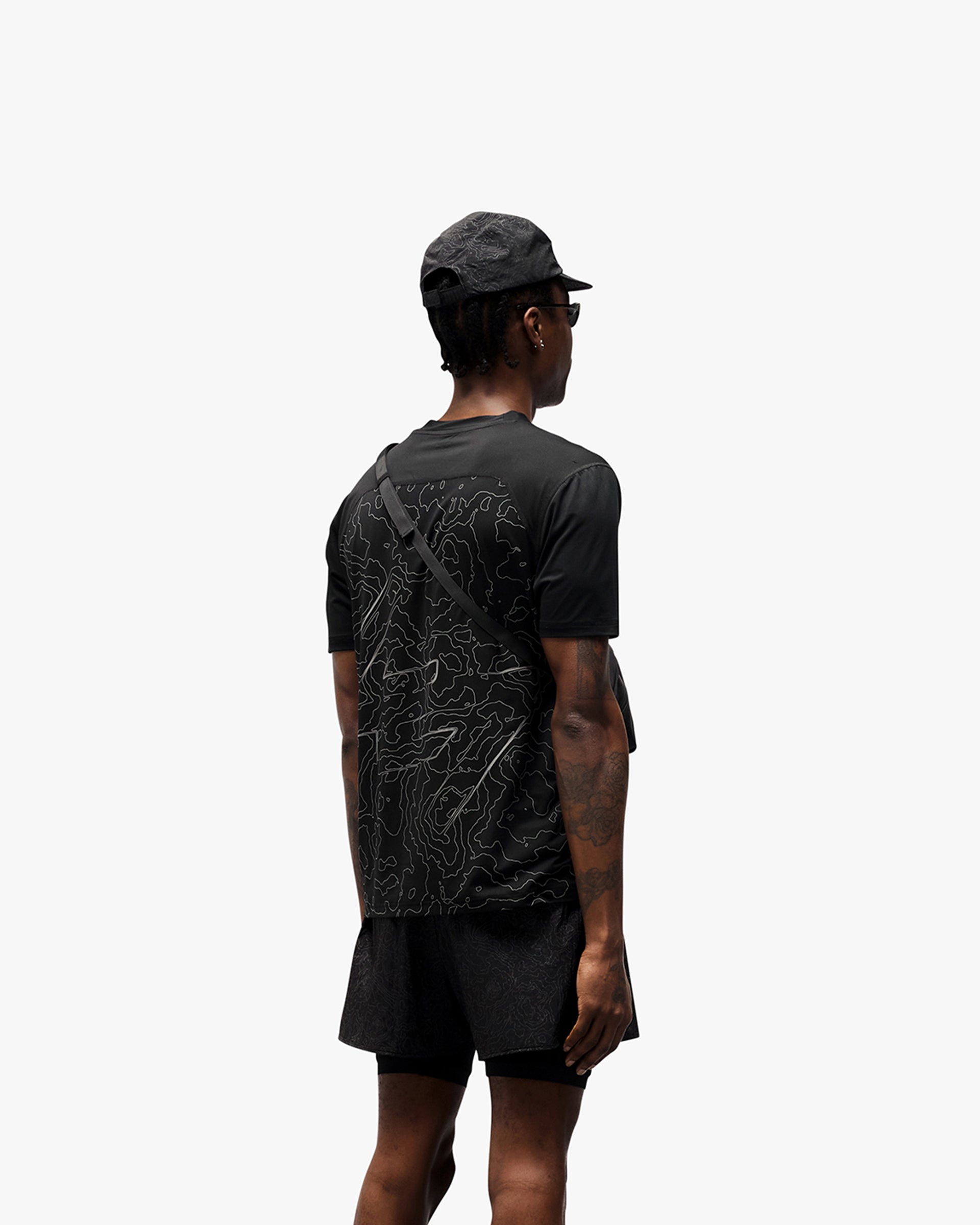 Man wearing a black running t-shirt on a plain white background | 247 Contour Run T-Shirt in Black | Breathable mesh running t-shirt with reflective contour print | 247 T-Shirts | Represent Clo