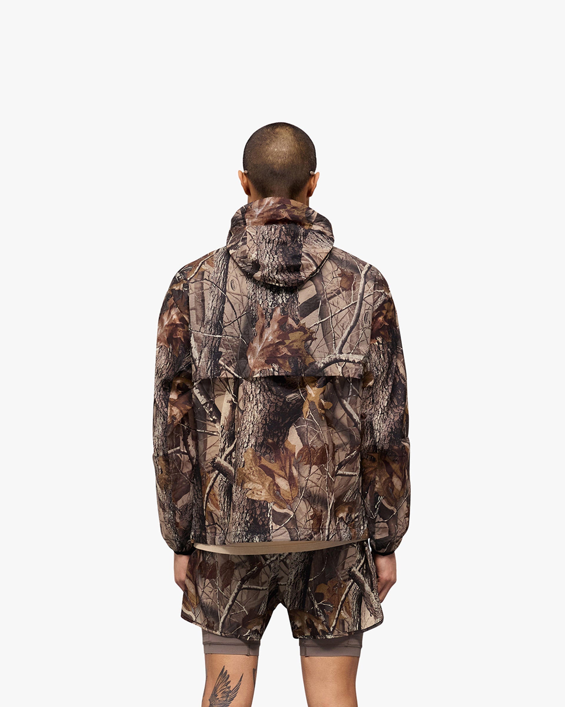 Man wearing a Realtree camo performance jacket on a plain white background | 247 Hooded Training Jacket in Realtree | Polyester jacket with DWR coating and adjustable toggles | 247 Outerwear | Represent Clo