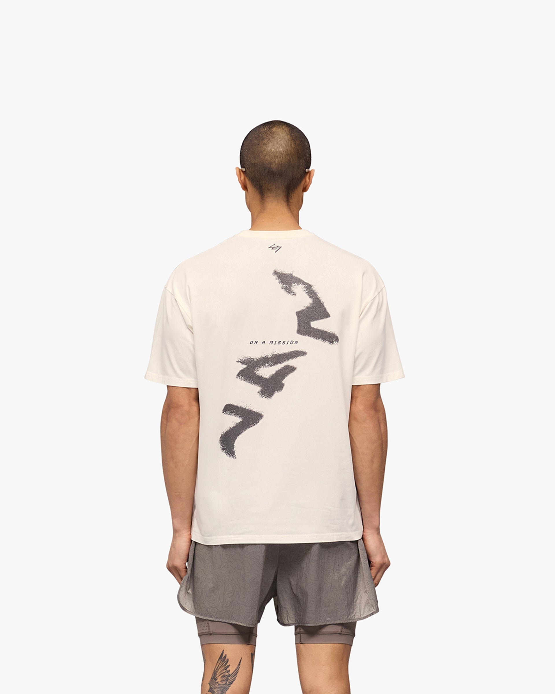 Man wearing an oversized white t-shirt on a plain white background | 247 Motion Oversized T-Shirt in Flat White | Oversized t-shirt with 2 way stretch and sweat wicking | 247 T-Shirts | Represent Clo