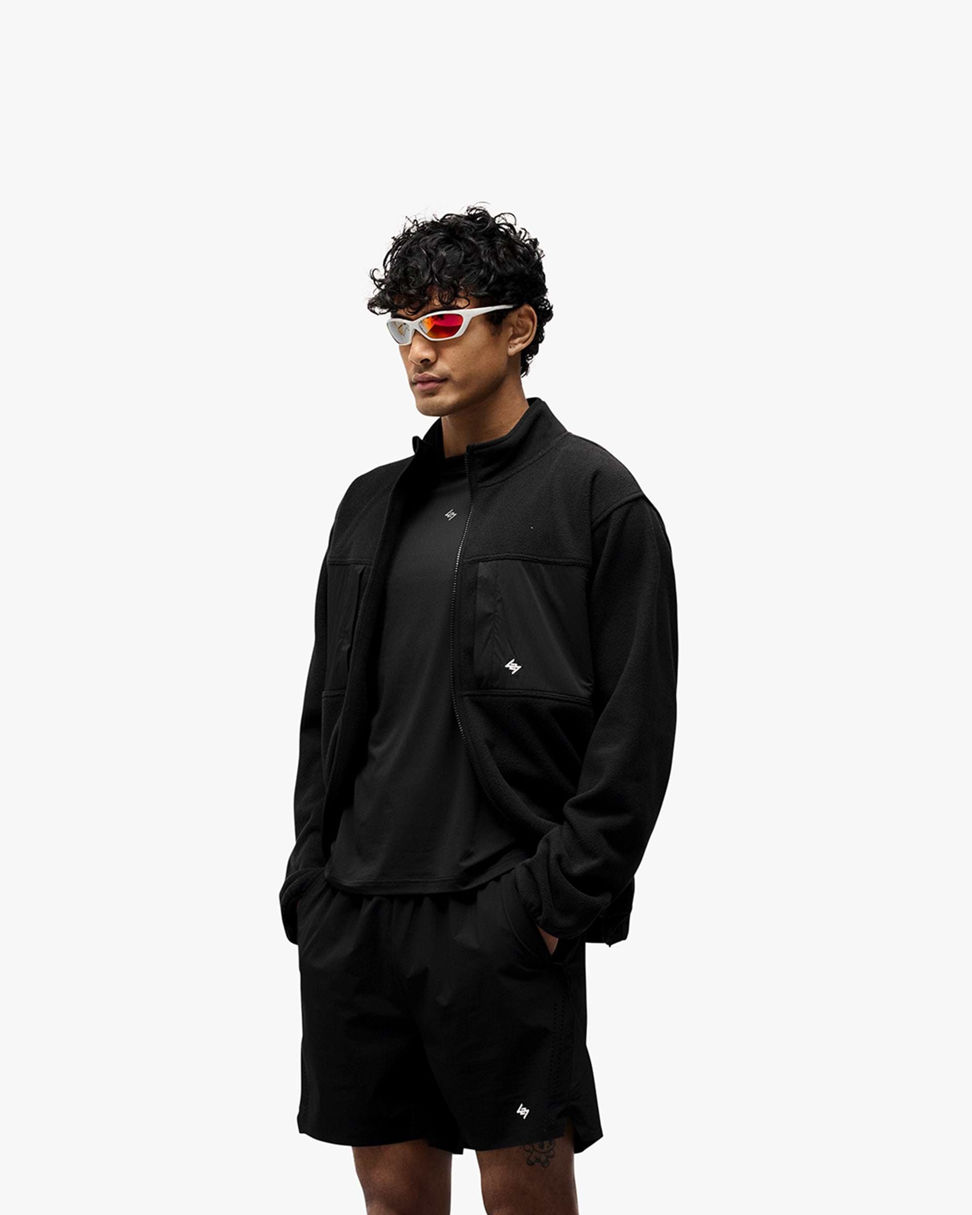 Man wearing a black fleece on a plain white background | 247 Polar Panelled Fleece in Black | Fleece with four zip pockets and toggle hem | 247 Outerwear | Represent Clo