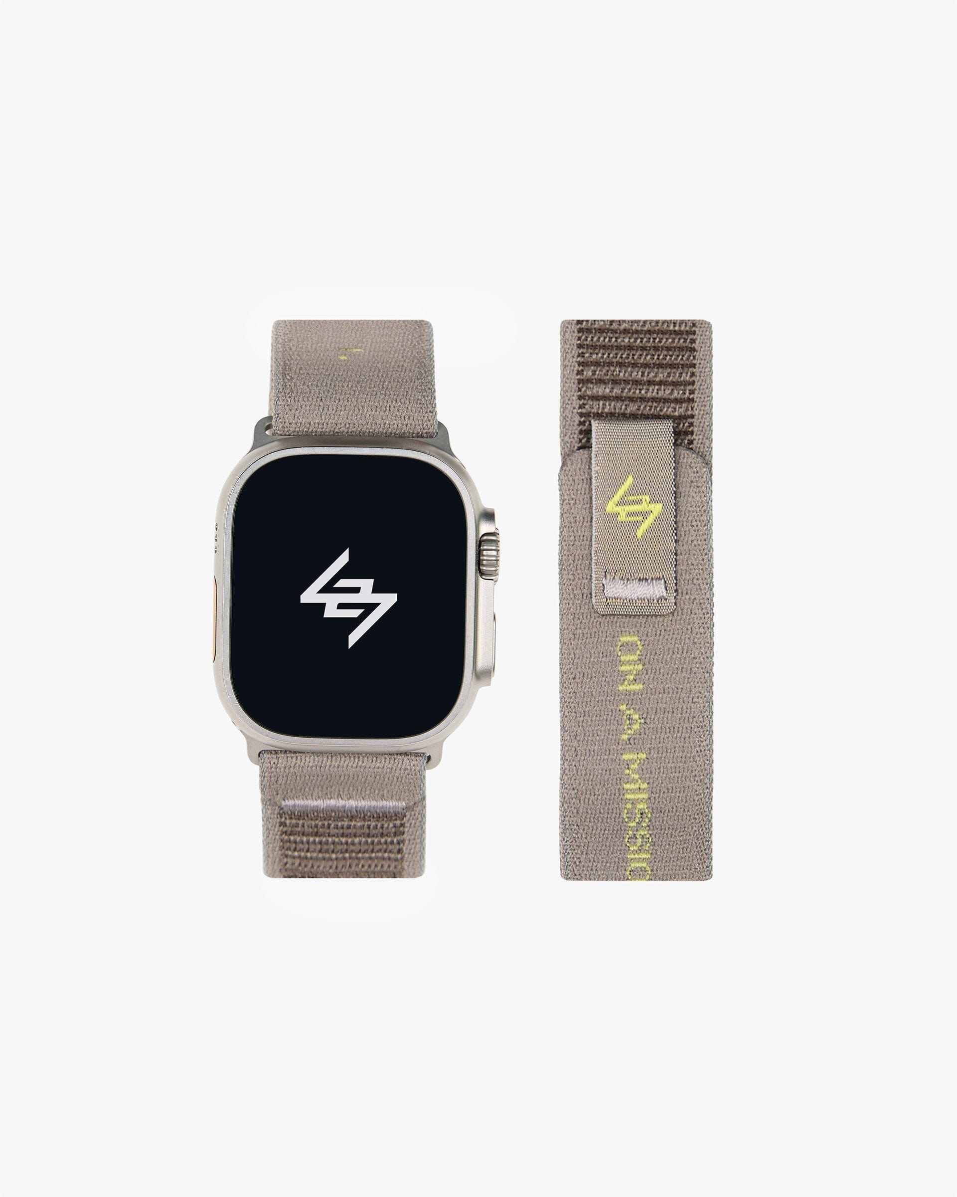 Back product image of a mens grey Apple watch strap on a plain white background | 247 Apple Watch Strap in Pebble | Nylon weave strap with velcro fastener and jacquard branding | 247 Accessories | Represent Clo